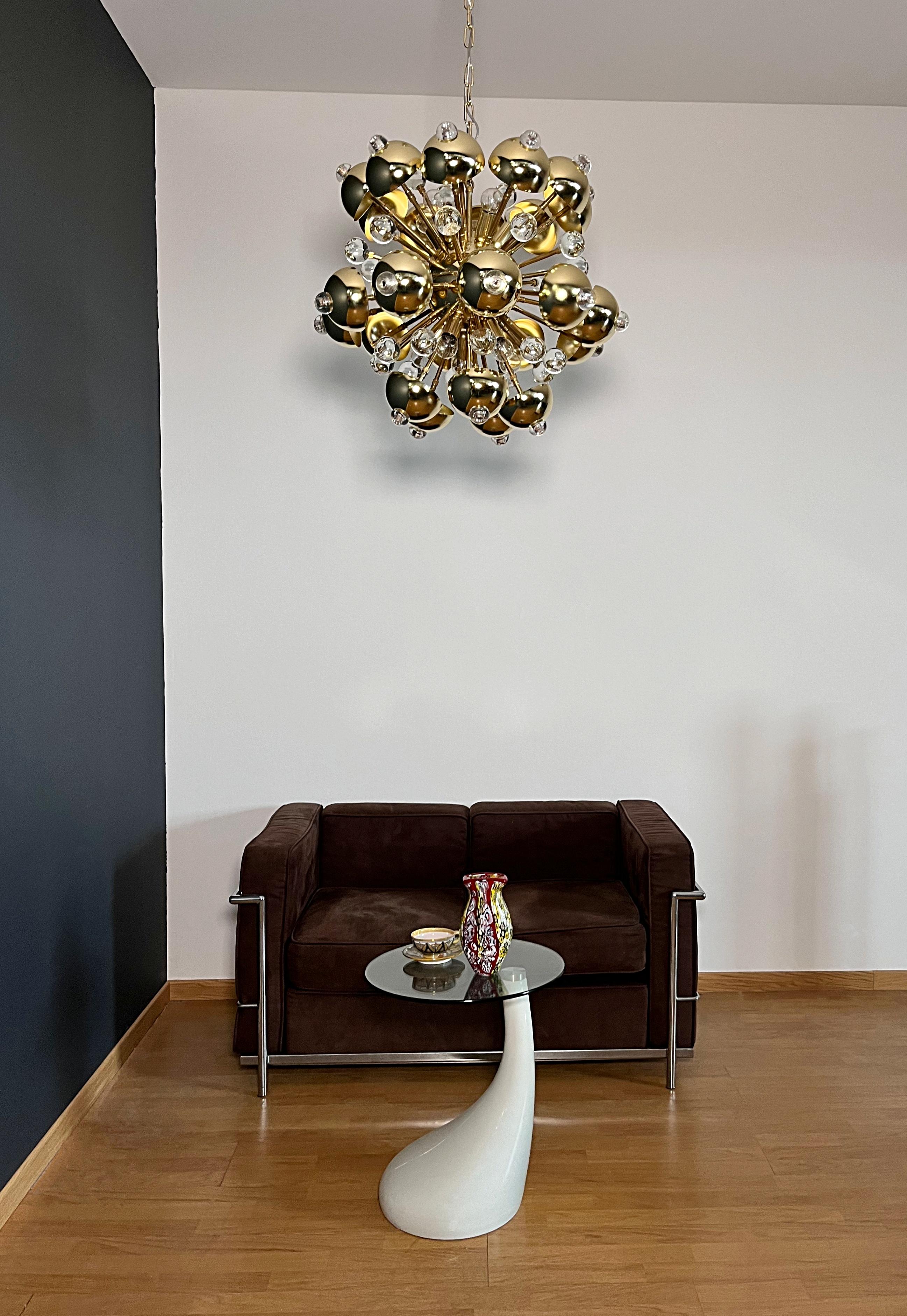 Impresionante araña de cristal de Murano y latón. De metal latonado con elegantes difusores esféricos de cristal. La lámpara está recubierta de cristal artístico que difunde la luz de forma única y muy encantadora desde los diez portalámparas. Cada
