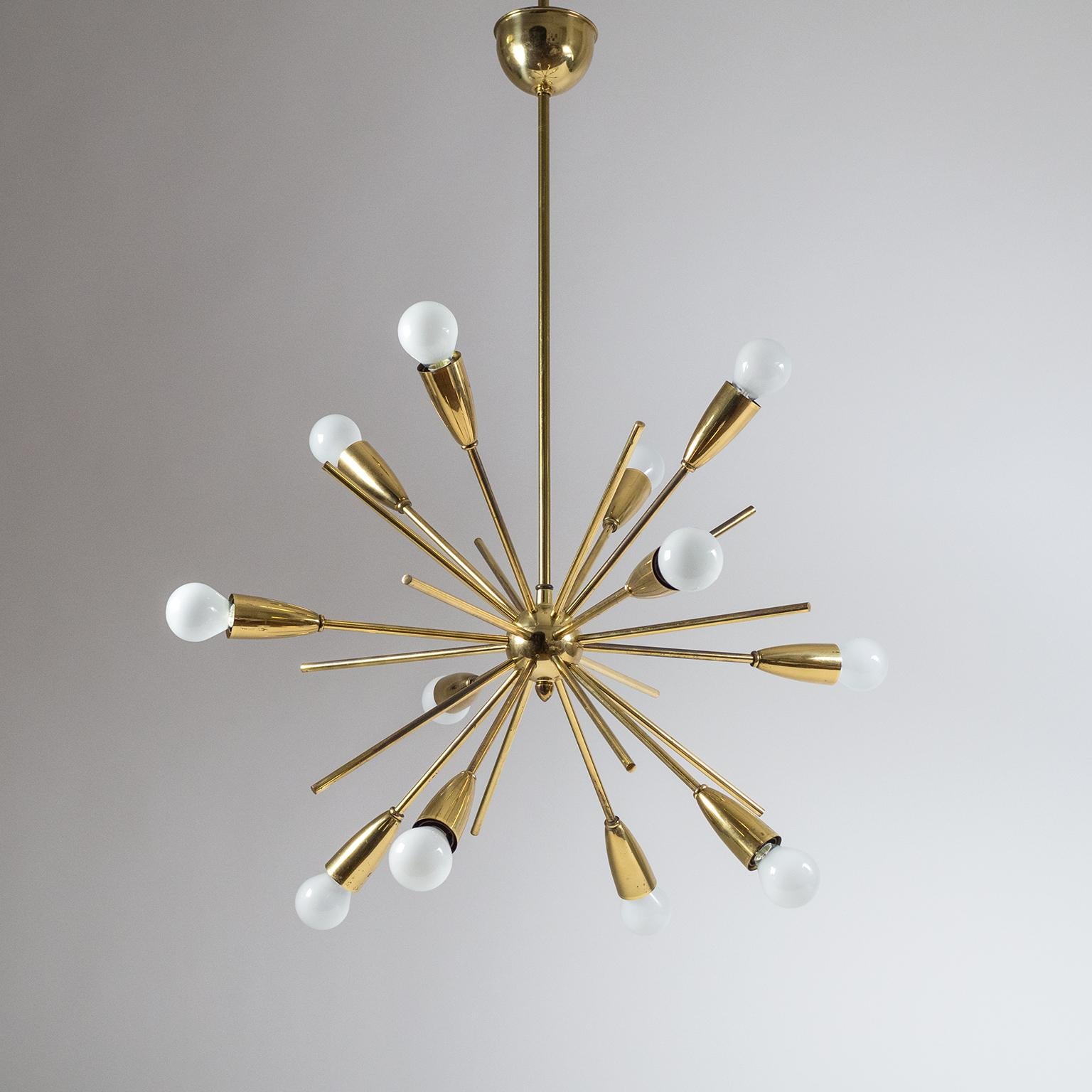 Excellent all brass 12-light Sputnik chandelier form the 1950s. In addition to the arms with bulbs there are 12 slightly shorter brass rods mixed in, giving this chandelier a very dynamic 'star burst' quality. Very nice original condition with a