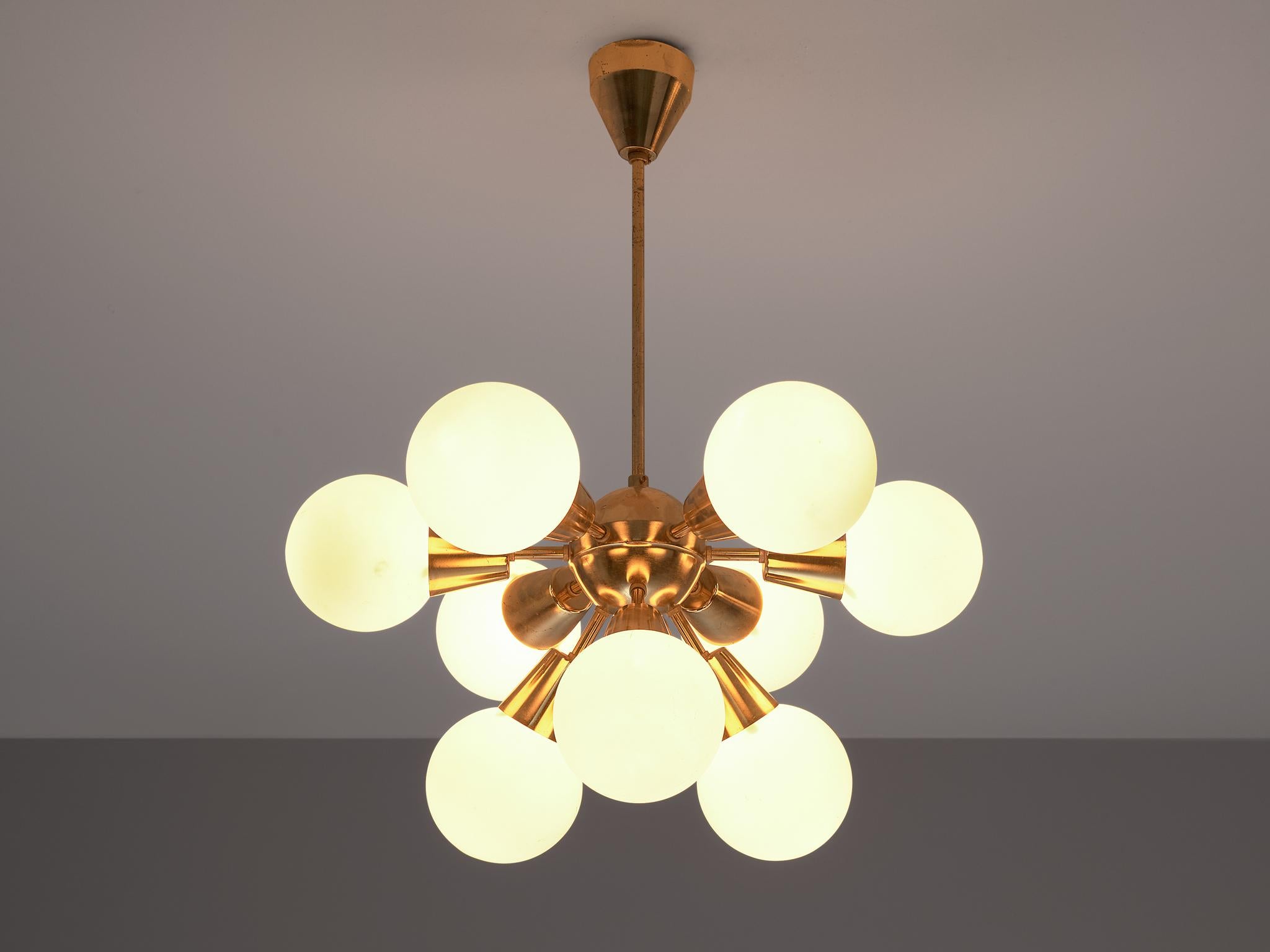 Sputnik chandelier, brass, opaline glass, Europe, 1970s.

The chandelier consists of a brass fixture with nine arms, all with an opal sphere. Due to the matted glass, these lights create a nice diffuse and soft light-tone. The brass shows an