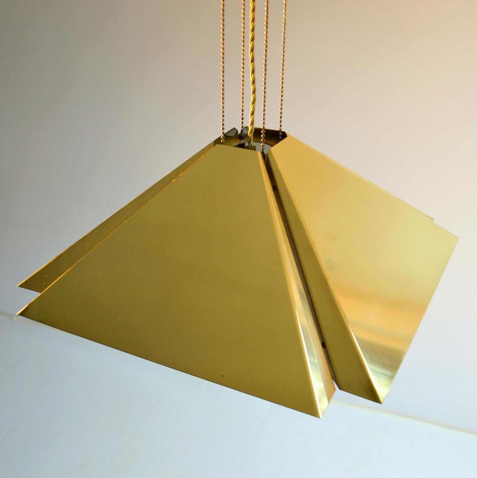 Le pendentif Quadratic en laiton, semblable à un mouchoir plié, de Dijkstra (Pays-Bas, 1970), est constitué de quatre sections de feuilles de laiton pliées et espacées pour créer un filet de lumière sur les quatre côtés. La lampe est suspendue à