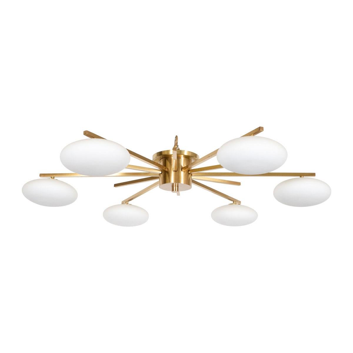 Brass starburst flush mount fixture with ovoid frosted glass shades.