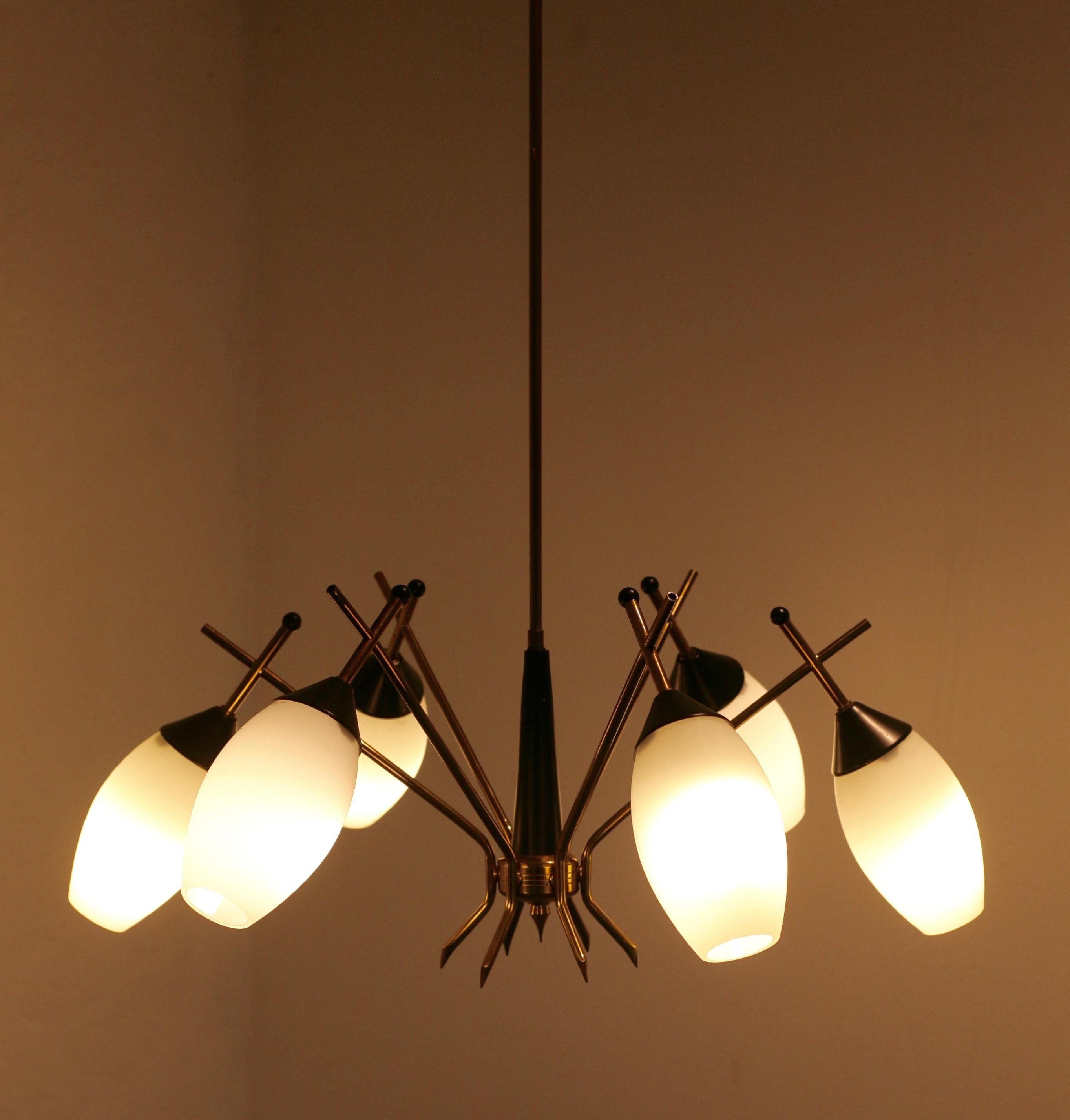 6-armed chandelier by Stilnovo. Brass and black bakelite. Opaque glass shades. Stilnovo label in ceiling cap.