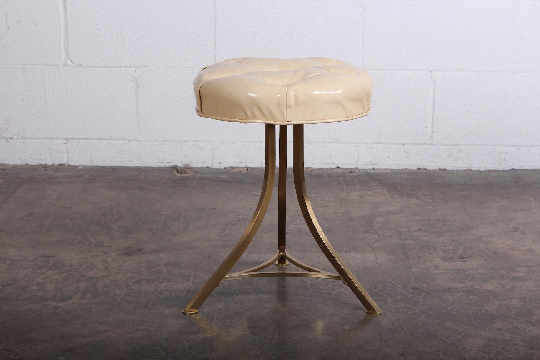 A swiveling brass vanity stool with original leather top. Designed by John Stewart.