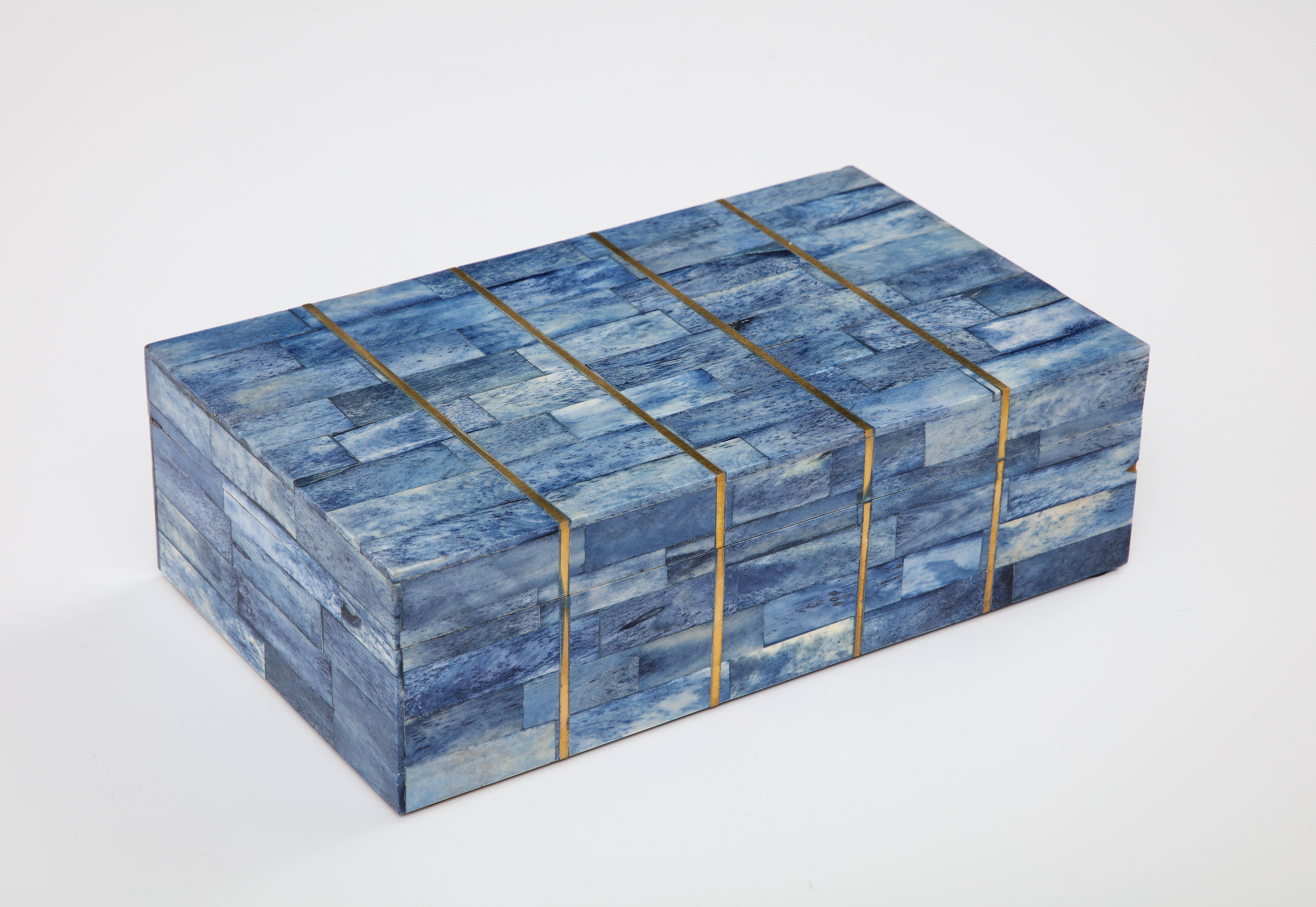 Fantastic keepsake box comprised of dyed blue bone segments inlaid with brass stripe details. A great addition to any coffee table or desk.
