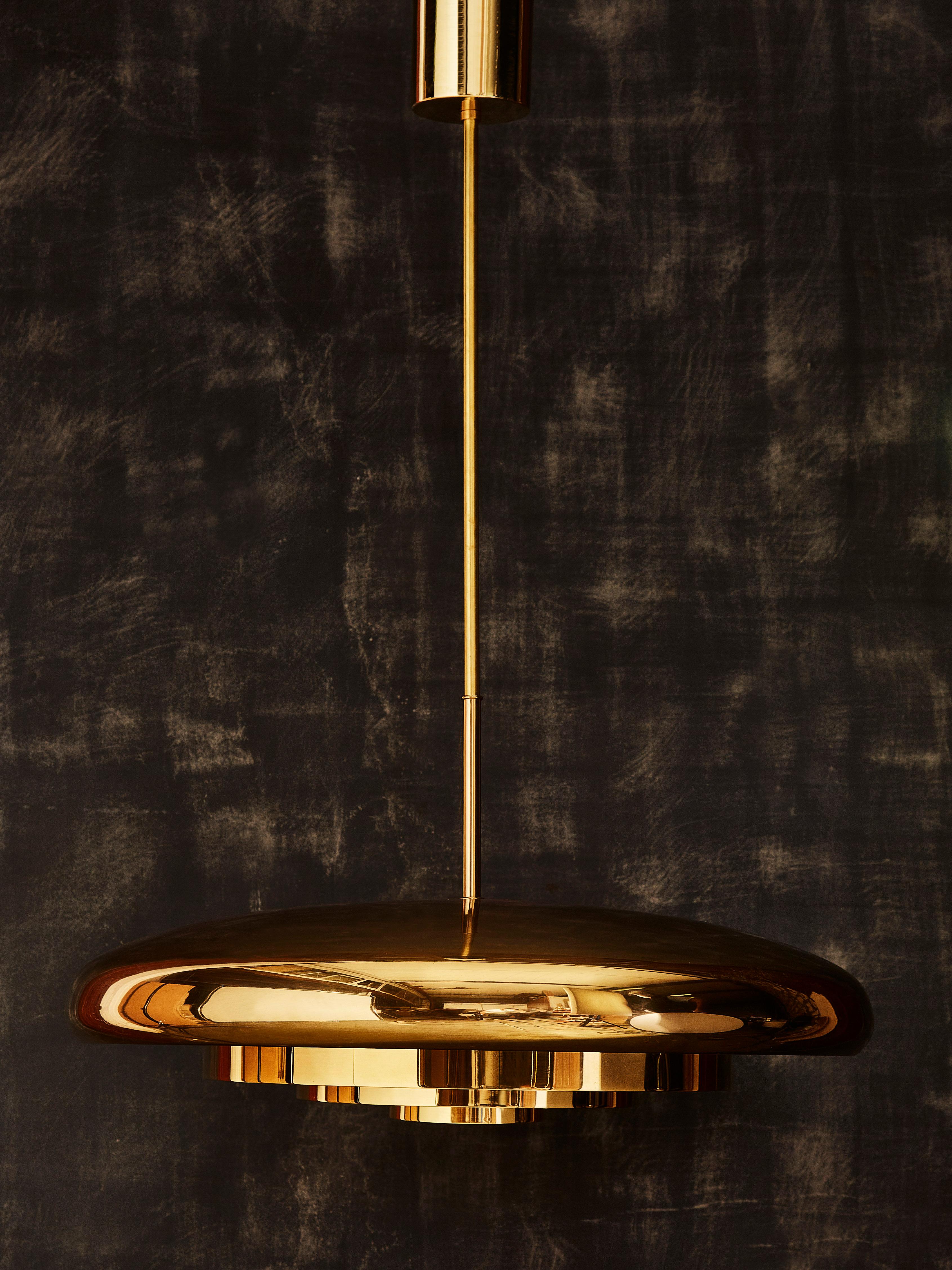 Three suspensions by Bergboms made of a brass round dome with three brass rings suspended giving the pendant texture and depth. The inside of the fixture is painted in white to ensure more light diffusion, one bulb per suspension.