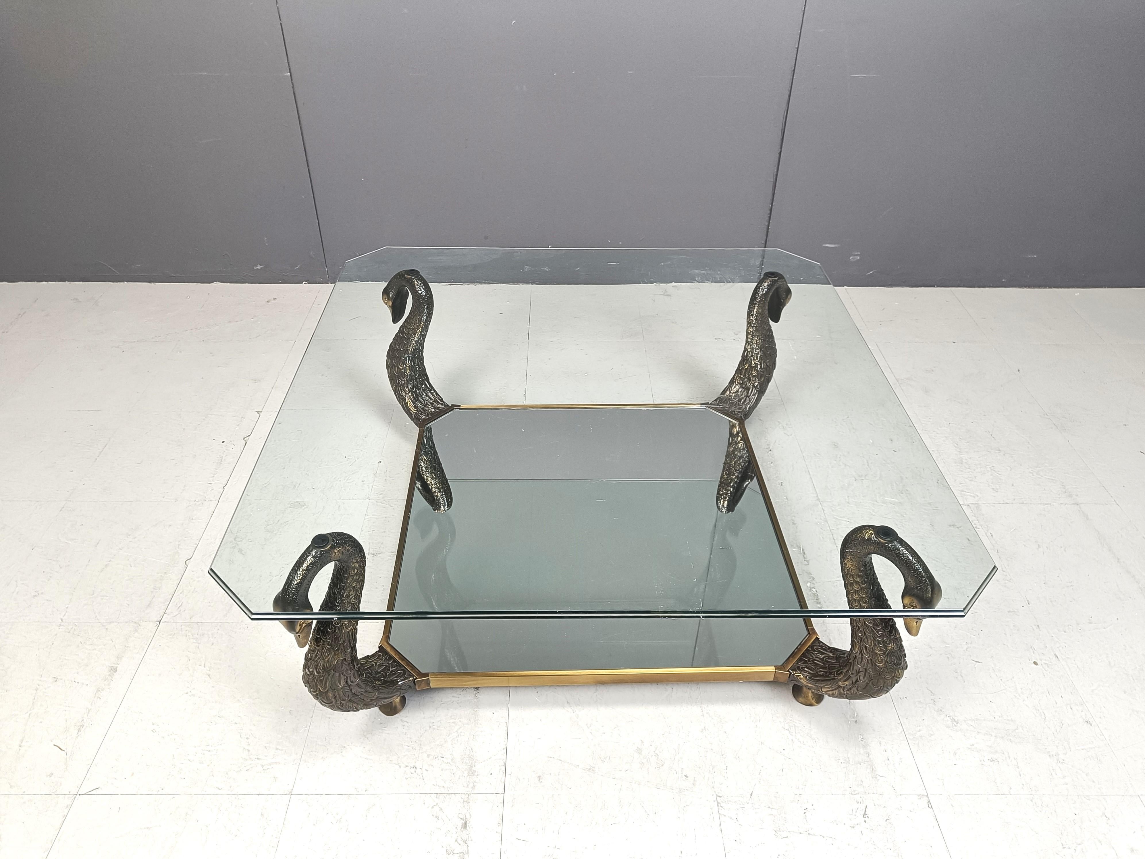 Table basse vintage haut de gamme en laiton et verre en forme de cygne.

La table basse se compose de 4 sculptures en col de cygne, finement détaillées, montées sur une base en laiton patiné supportant un verre transparent. Le verre inférieur est un