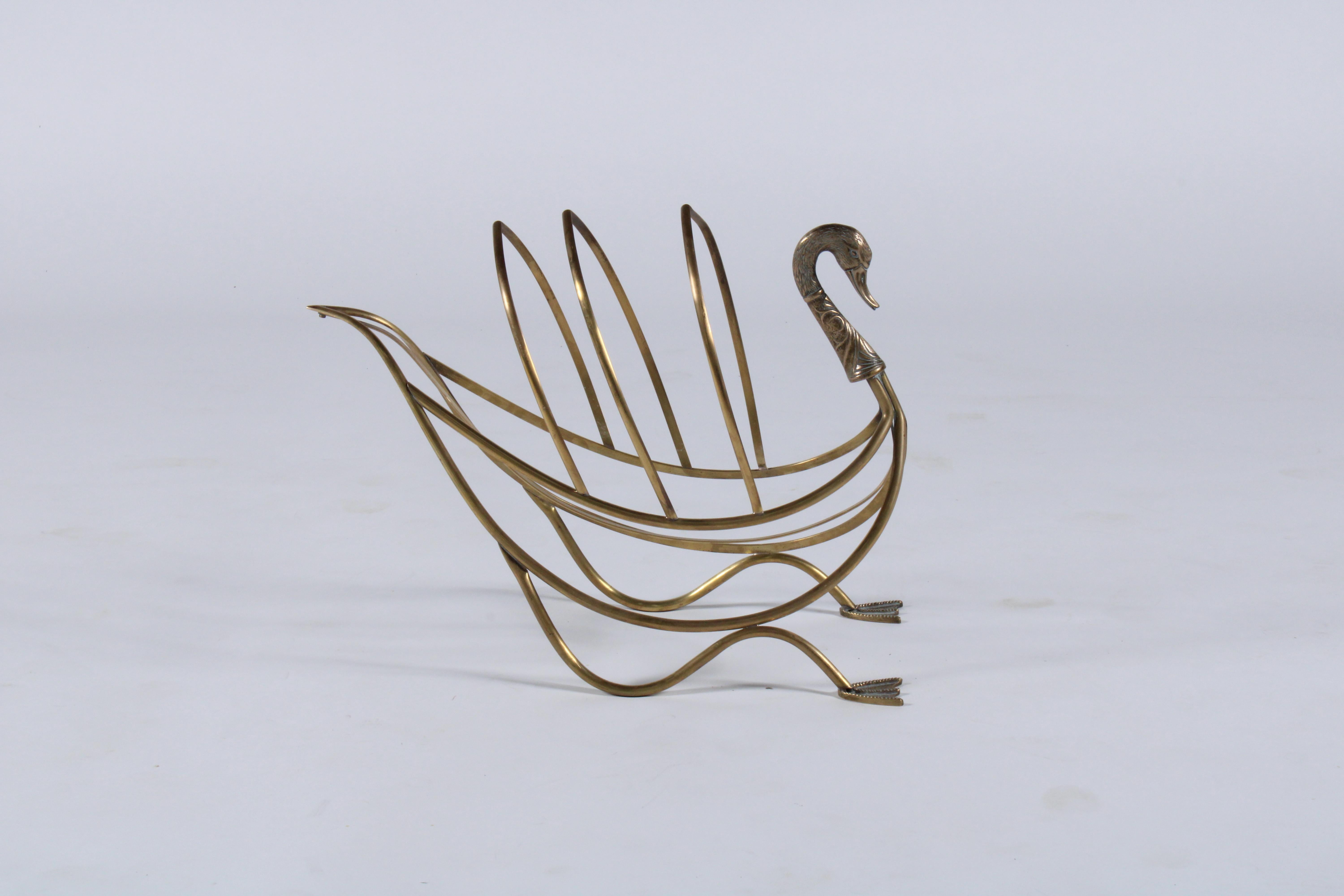 Vintage brass magazine rack in the form of a swan. Attributed to Maison Jansen of Paris this piece was produced circa 1960. A stylish decorative functional and fun piece for any home or commercial premises.