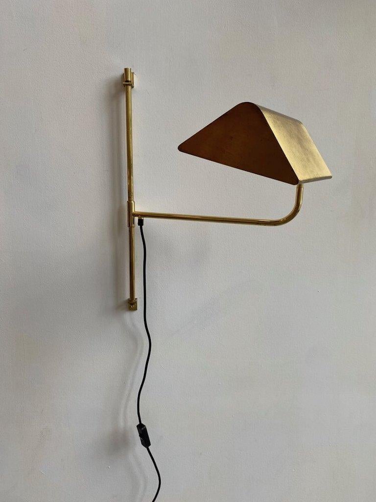 A brass wing arm adjustable wall sconce in the manner of Florian Schulz with an adjustable height, and arm. This lamp can be used as a desk lamp/task lamp and would also be perfectly situated over a sofa in a living room. Or a nightstand in a