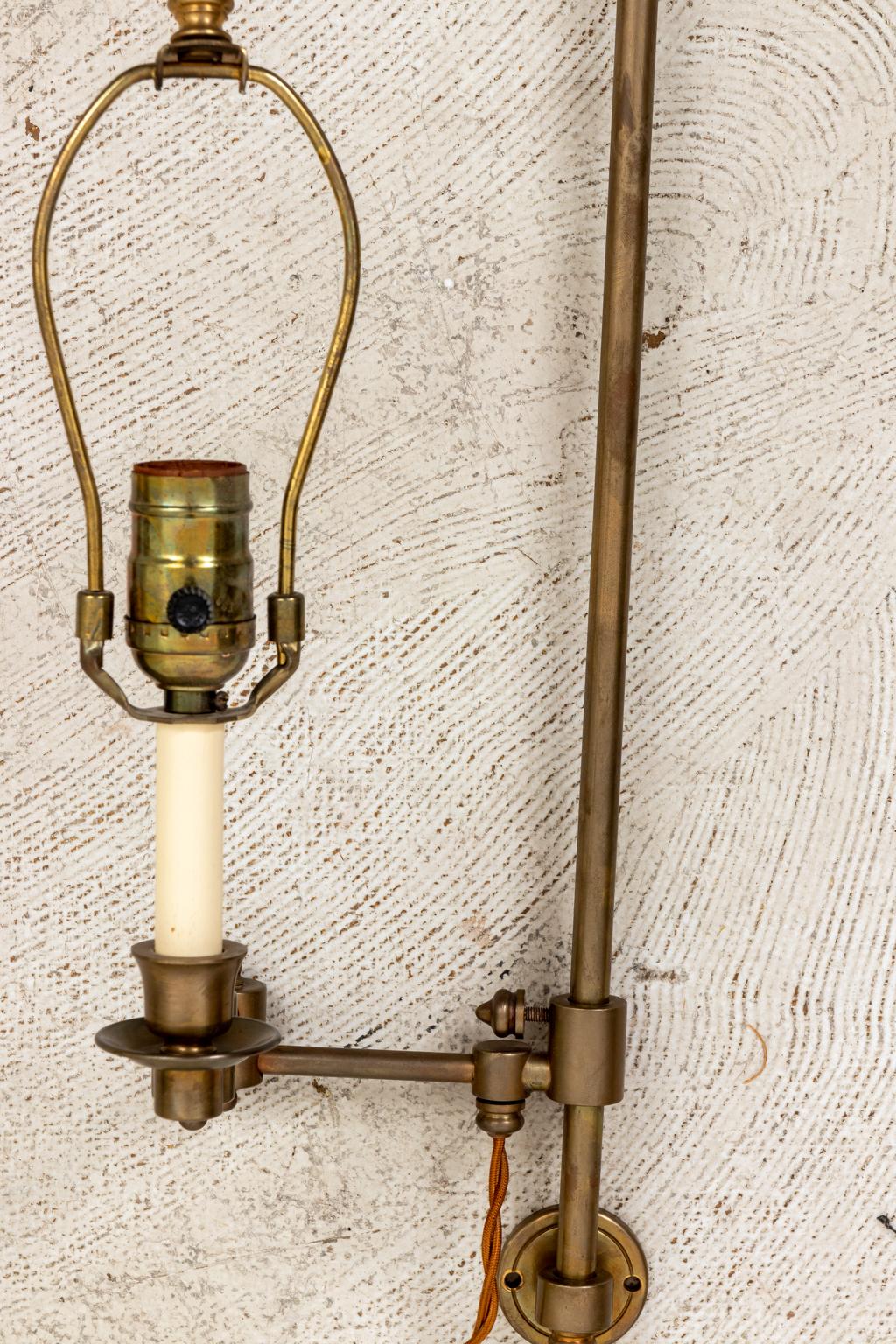 Pair of brass swing arm library sconces. Made in the United States. Please note of wear consistent with age. The sconces are in very good condition. Shades not included.