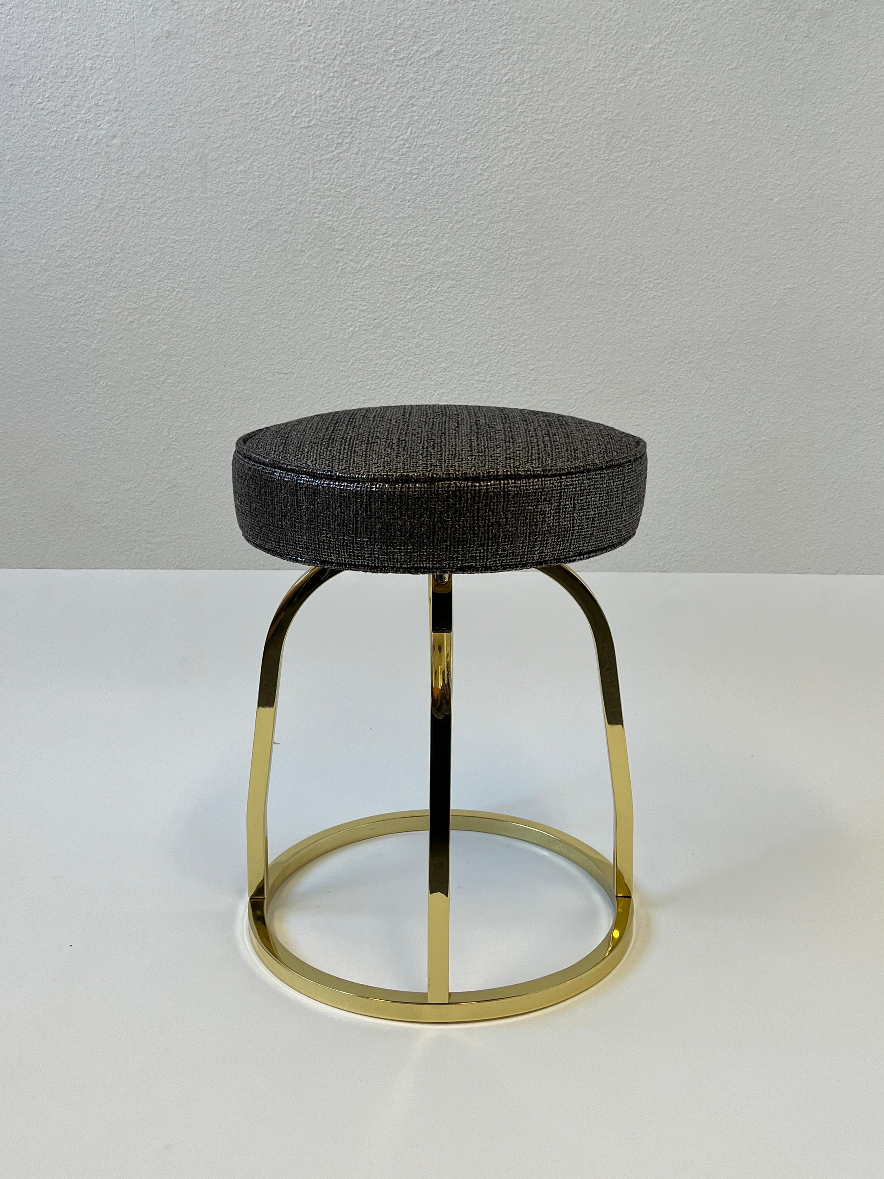 1970’s Glamorous polish brass swivel vanity stool in the manner of Charles Hollis Jones. 
New brown with a metallic silver sheen fabric. 

Measurements: 16” diameter, 20” high.