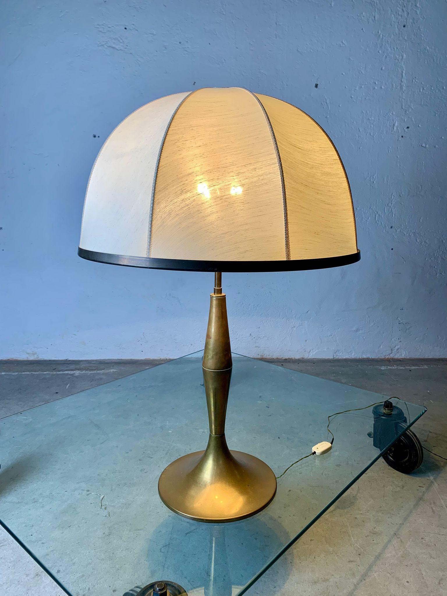 Brass table lamp and fabric lampshade, 1950s, italy.

Turned brass frame burnished by the patina of time, large shade (60 cm diameter) in ivory fabric, supported by internal metal frame.
Overall height 93 cm. Electrified.
good contition
