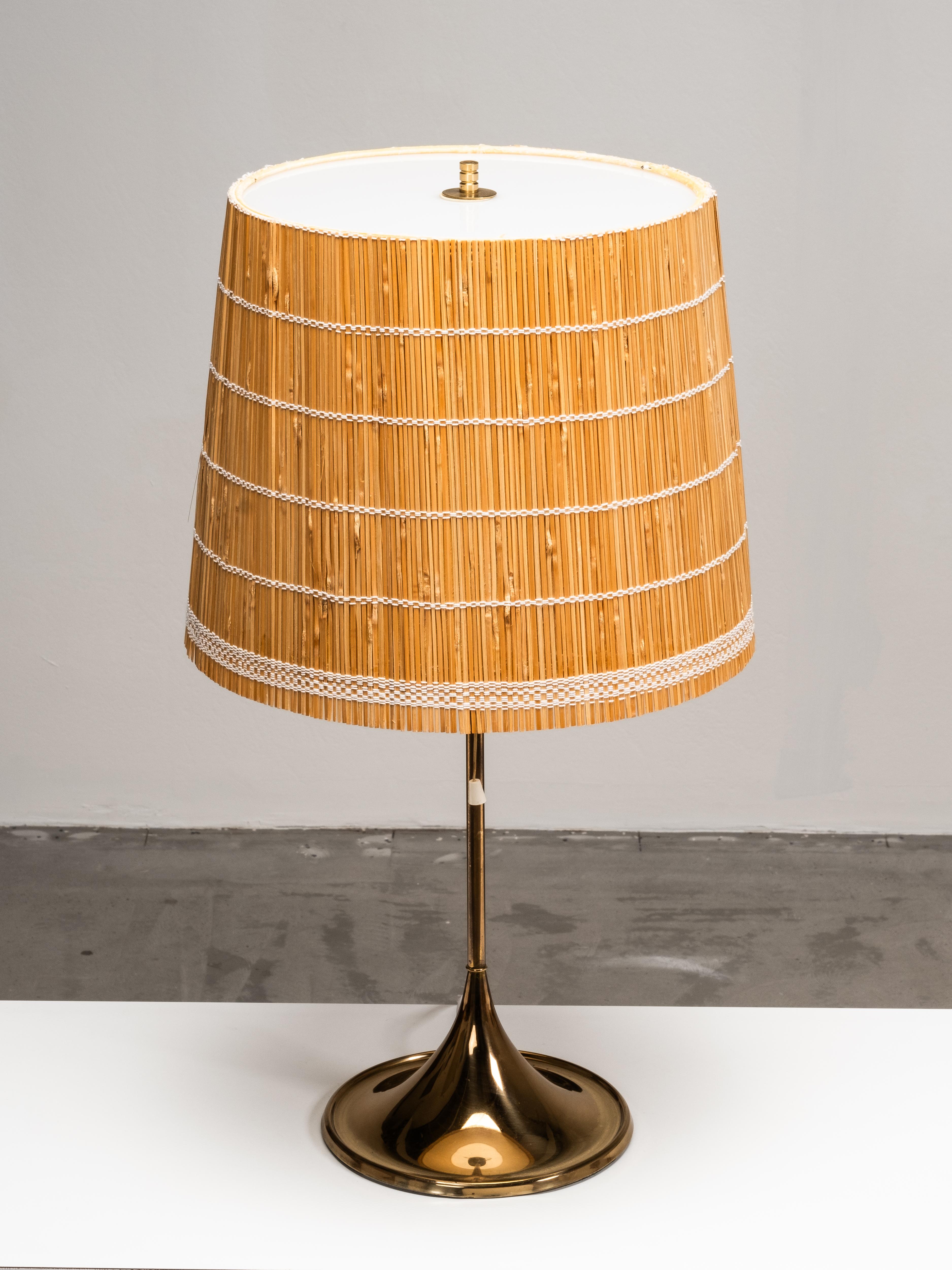 Una lampada da tavolo svedese in ottone, modello B-024, disegnata da Alf Svensson e Yngvar Sandström per Bergboms negli anni Sessanta. Il design è caratterizzato da una base in ottone a forma di tulipano con uno stelo sottile, abbinato a un paralume