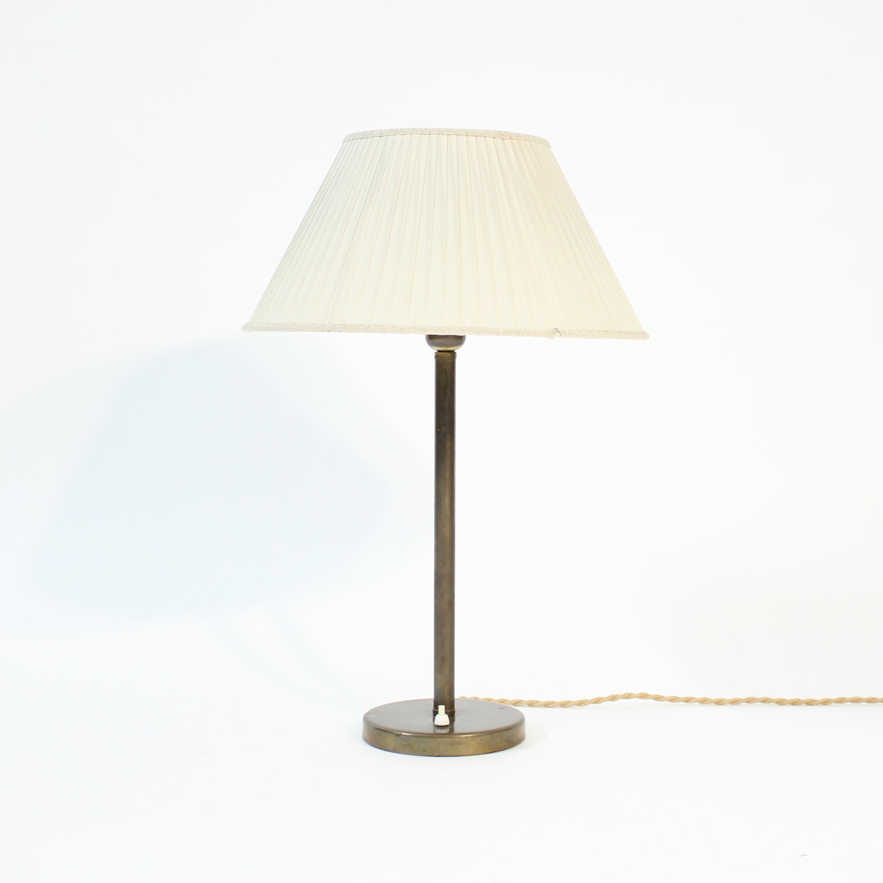 Large brass ASEA brass table lamp from the 1950s attributed to Hans Bergström, including the rare original off-white pleated shade. New wiring and plug. Very good vintage condition with light ware consistent with age and use. 