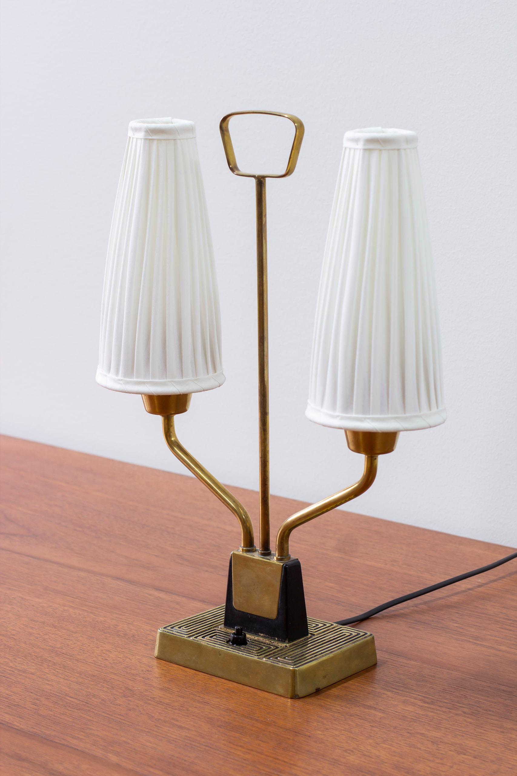 Table lamp produced in Sweden by ASEA belysning during the 1950s. Made from brass and black lacquered wood with new hand sewn lamp shades in chintz fabric. Light switch on the lamp base in working order. Very good vintage condition with light age