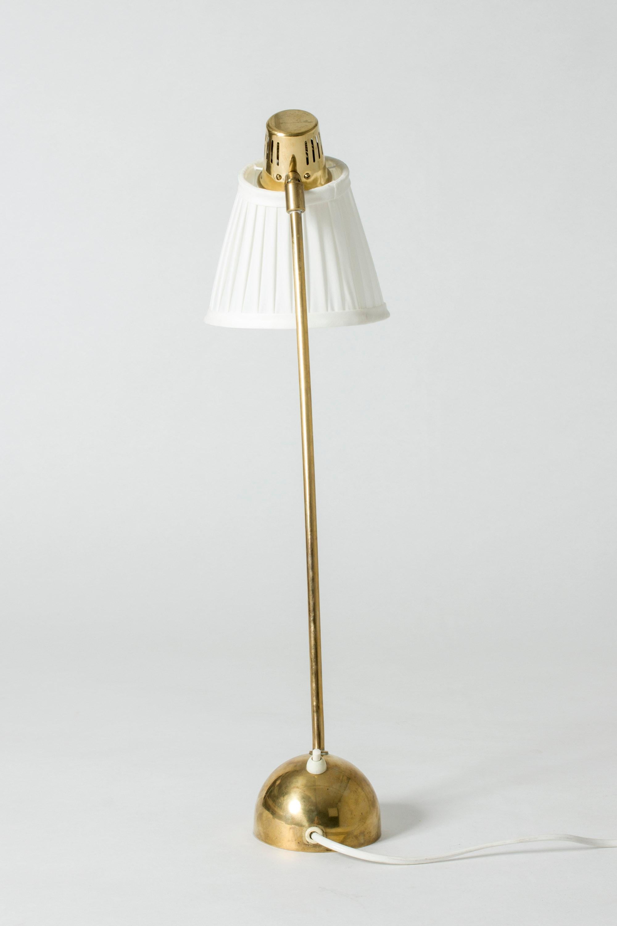 Elegant brass table or desk lamp by Hans Bergström with an elongated shaft and adjustable shade. Rounded base, nice silhouette.
