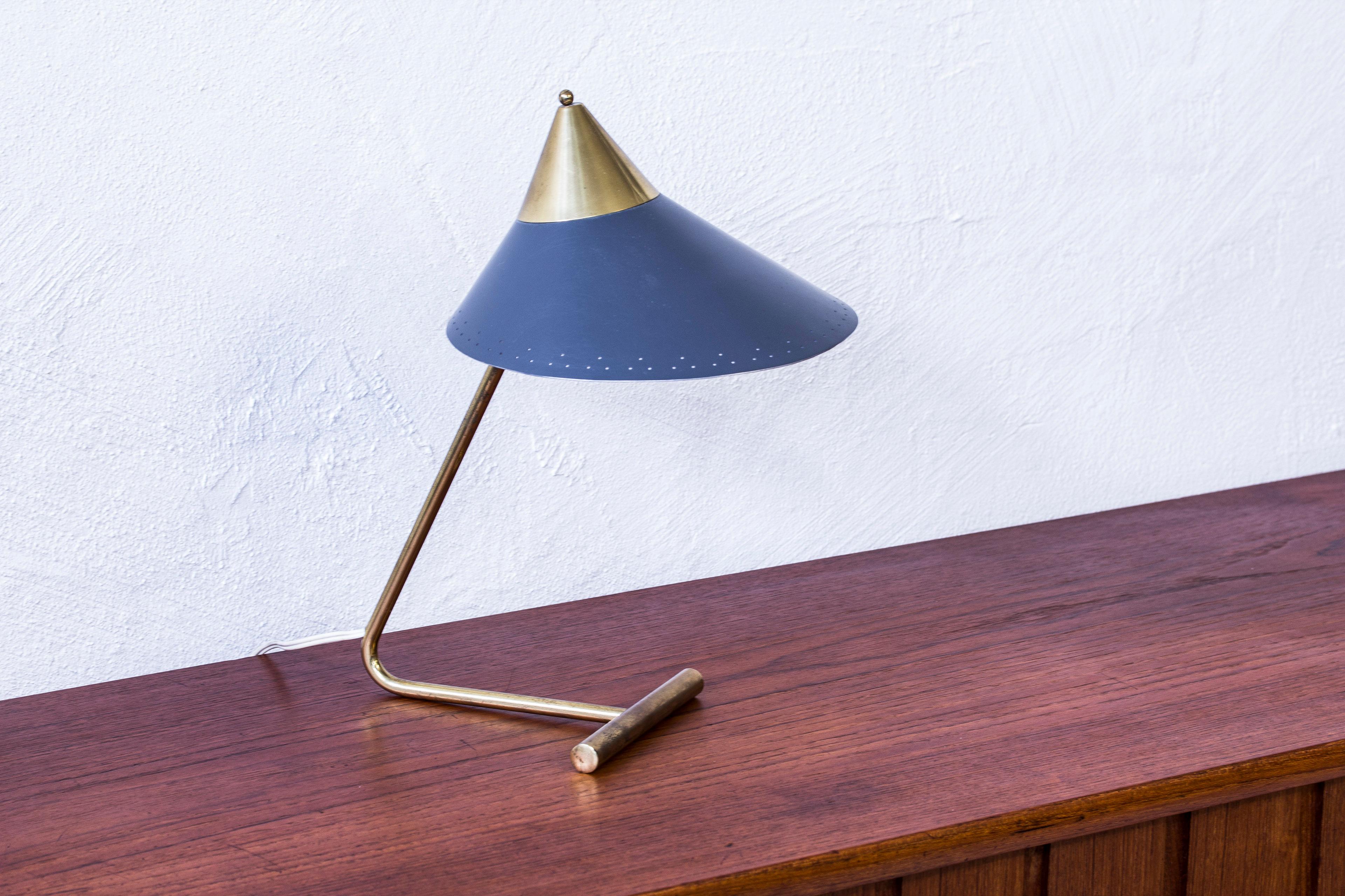Table lamp designed by Svend Aage Holm Sørensen. Produced by his own company in Denmark during the 1950s. Made from polished brass with a grey lacquered metal shade. Light switch on the chord. Very good condition with few signs of wear and light age