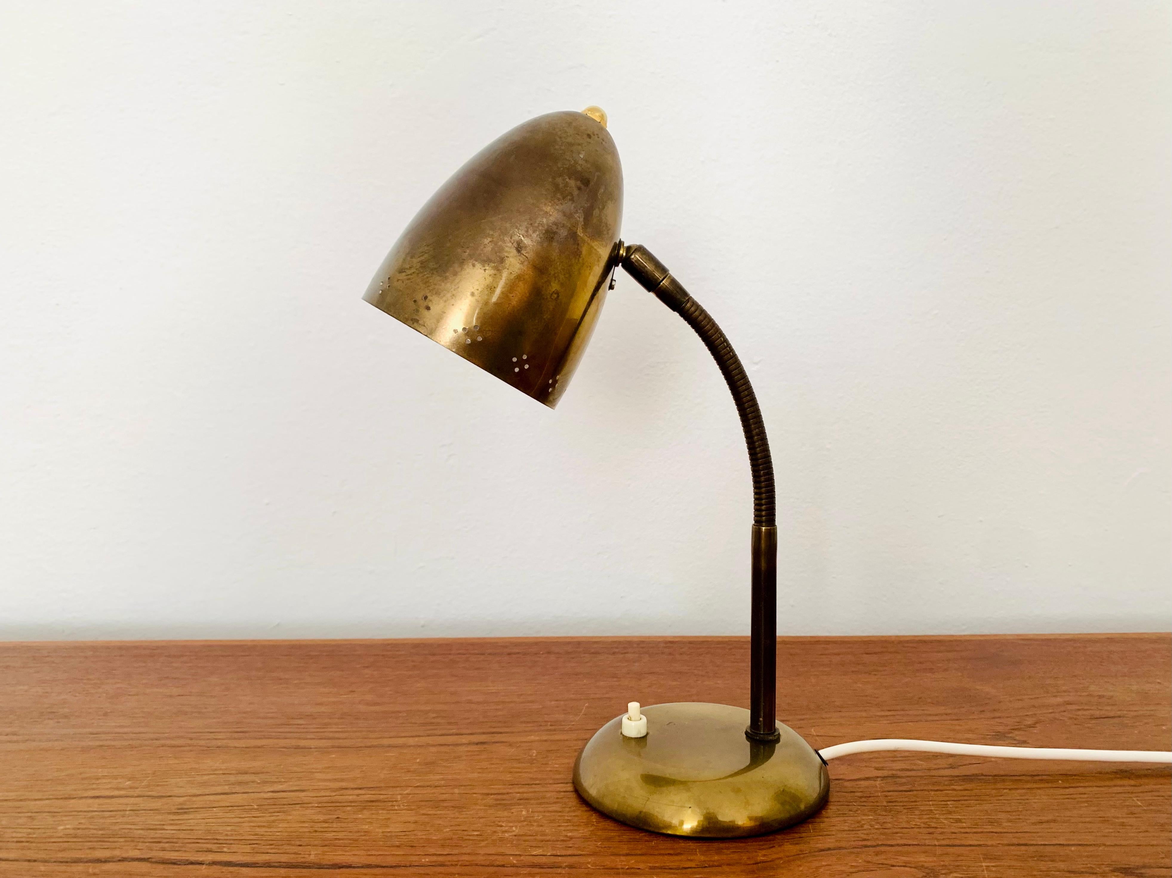 Très belle lampe de table dorée des années 1950.
Fantastique design du milieu du siècle.
La combinaison d'un travail de haute qualité et de détails soignés enrichit chaque maison.
Les trous décoratifs dans l'abat-jour créent un magnifique jeu de
