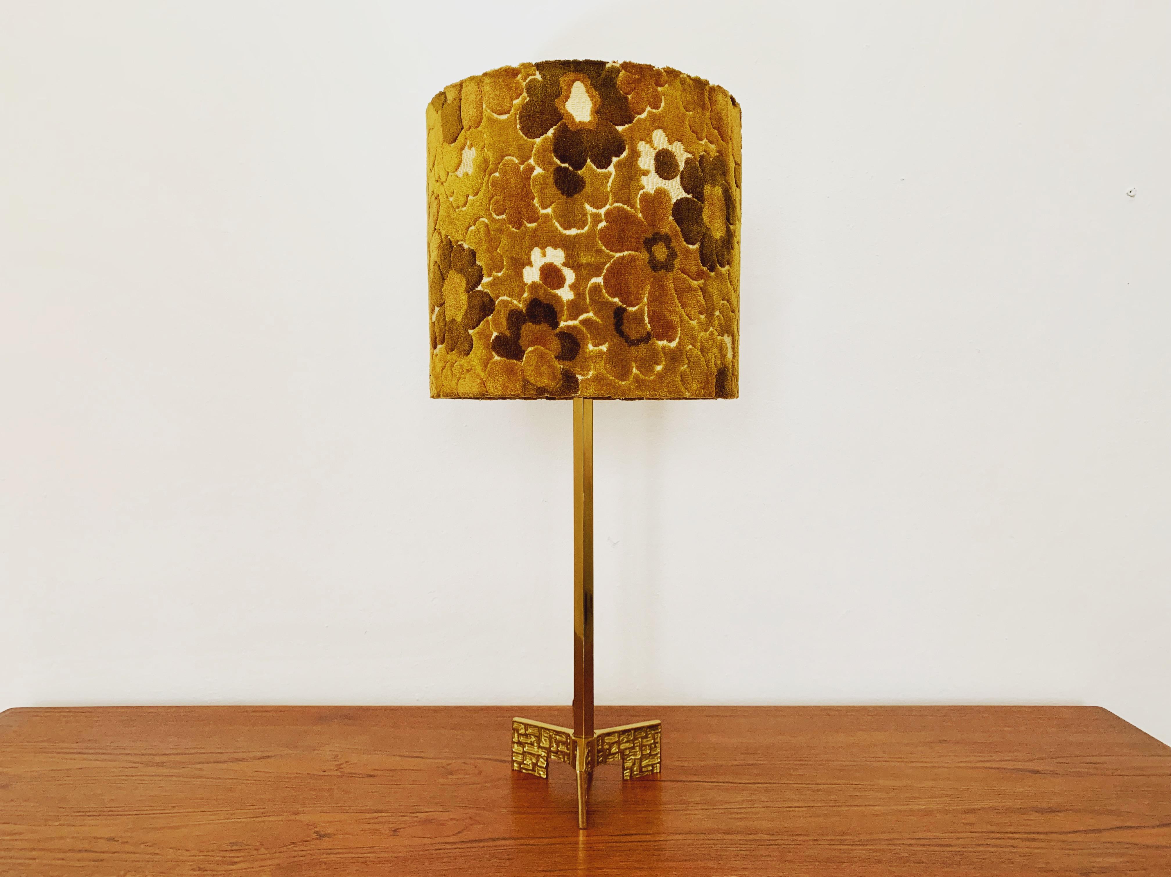 Impressive beautiful table lamp from the 1960s.
Beautiful brutalist details and an asset to any home.
The lampshade with the floral pattern is a real eye-catcher and spreads a very warm light.

The integrated pull switch has 3 switching
