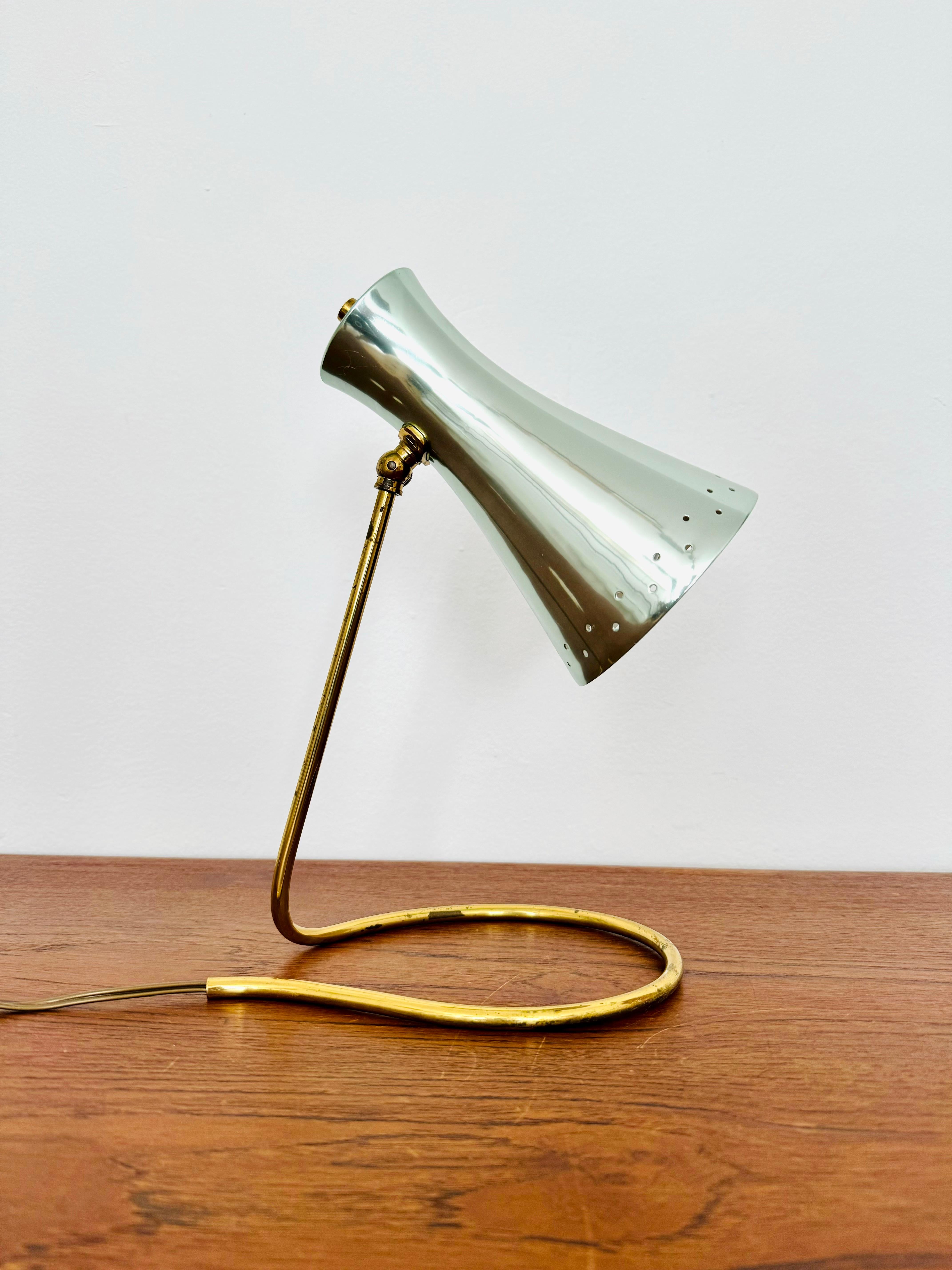 Très belle lampe de table des années 1950.
Fantastique design du milieu du siècle.
La combinaison d'un travail de haute qualité et de détails soignés est un enrichissement pour chaque maison.
Les trous dans l'abat-jour créent une lumière