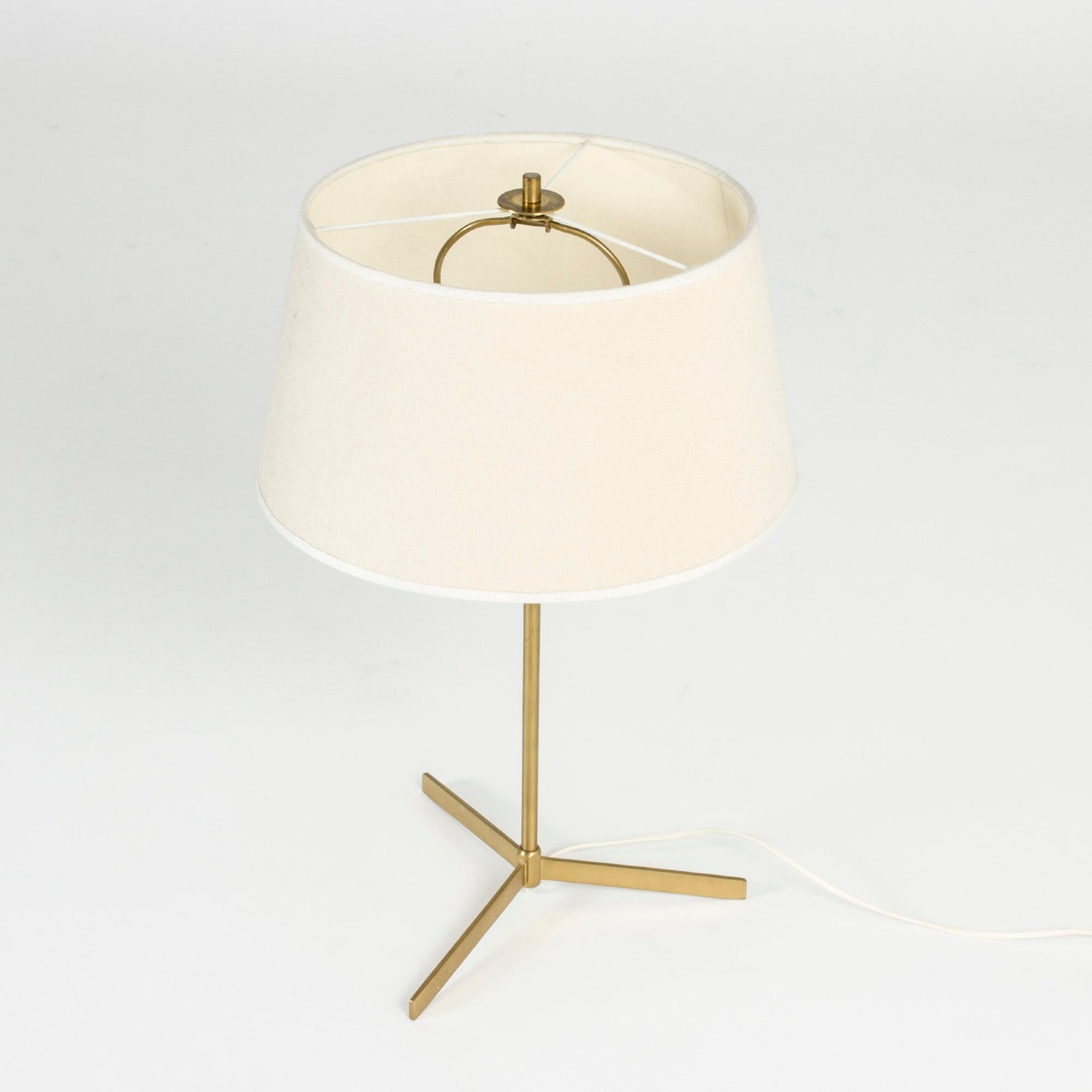 Table lamp from Bergboms with a lanky and angular brass base and cream colored textile shade. Nice proportions.
