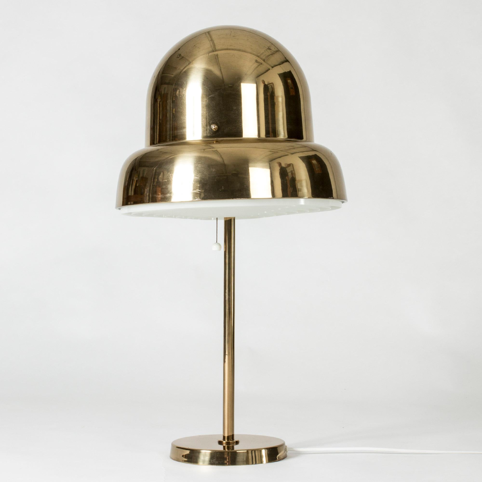 Cool brass table lamp from Bergboms, with an oversized lampshade in a rounded, organic form. A lamella shields the light on the underside.