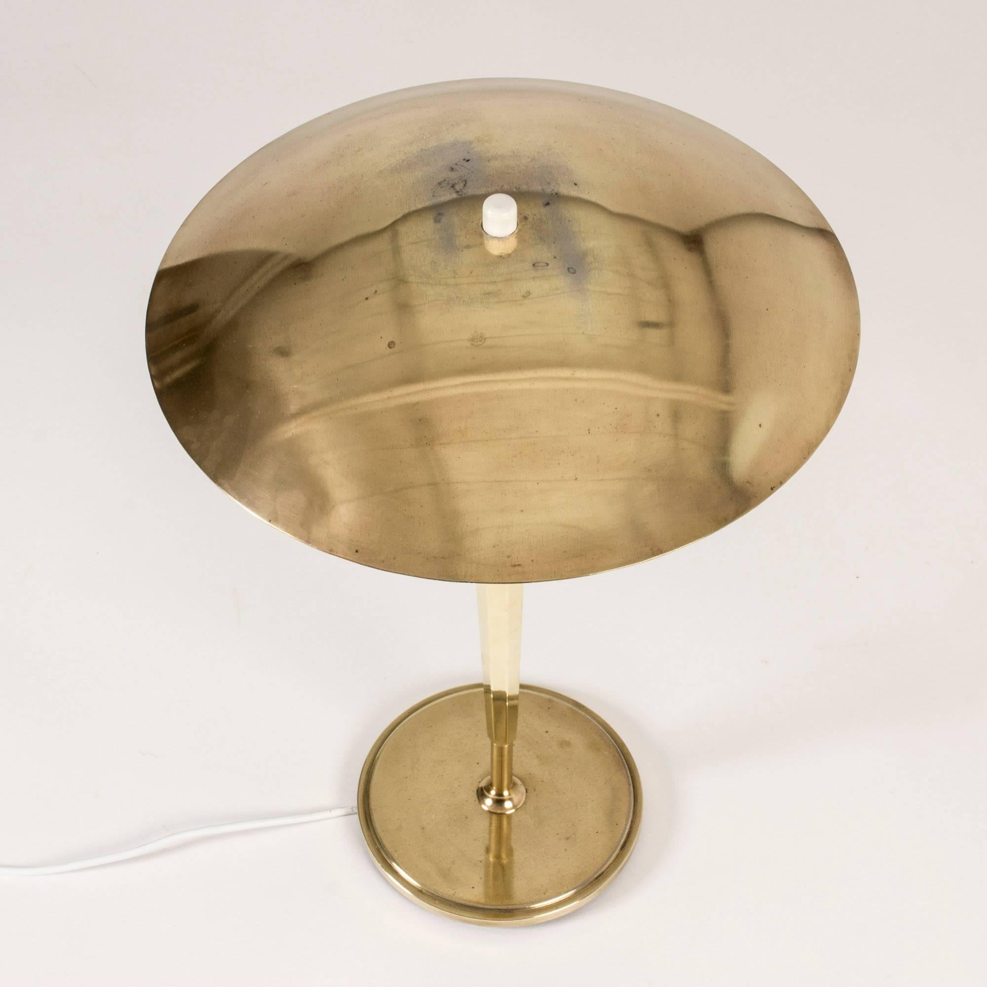 Striking brass table lamp from Böhlmarks, with a statuesque design. Light switch found on top of the dome shaped shade.