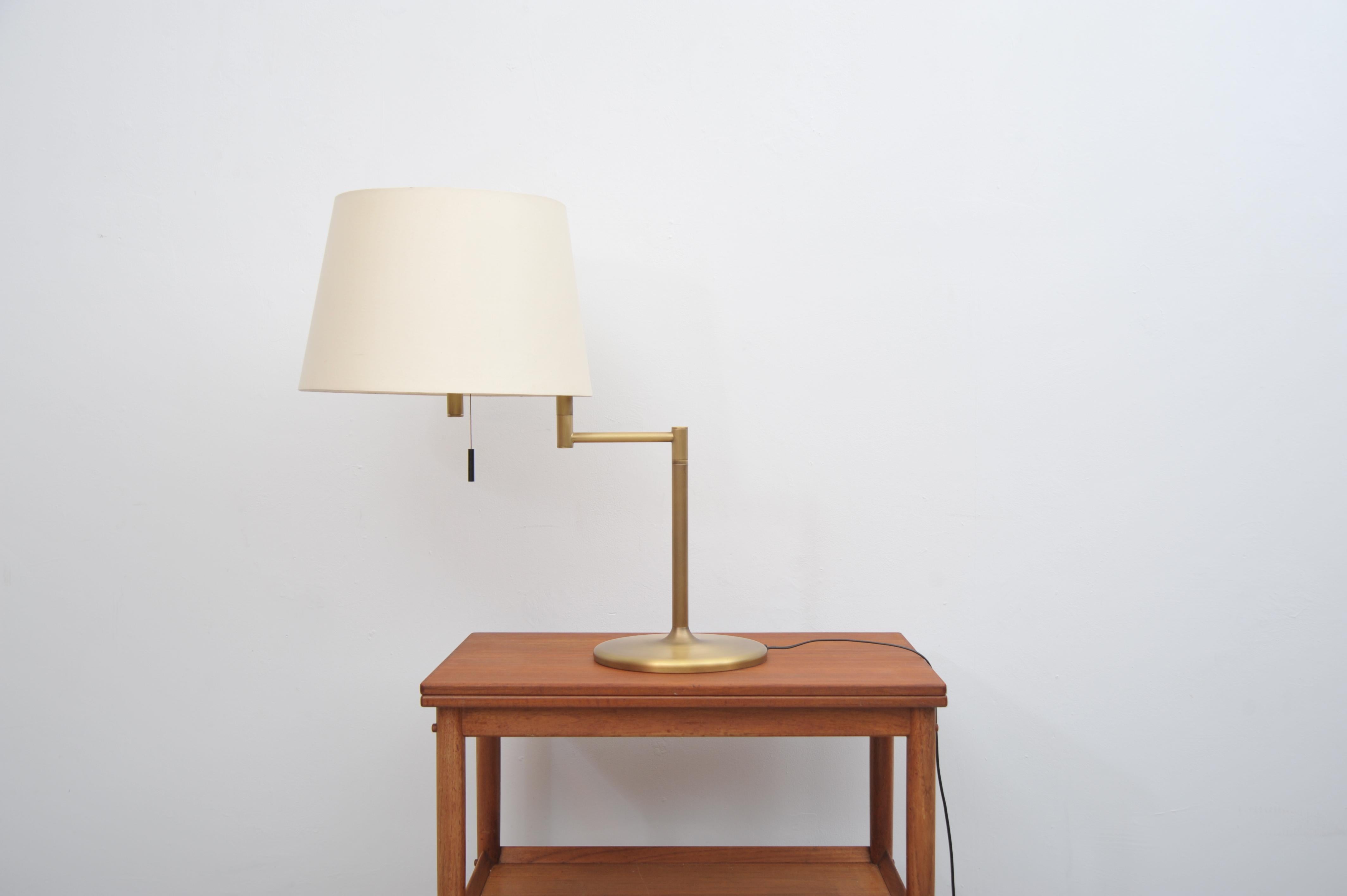 Lampe de table en laiton avec bras rotatif, produite par Swiss Lamps International dans les années 1970. La lampe est dotée d'un bras rotatif et d'un abat-jour large et évasé. 
En très bon état vintage avec seulement des signes minimes
