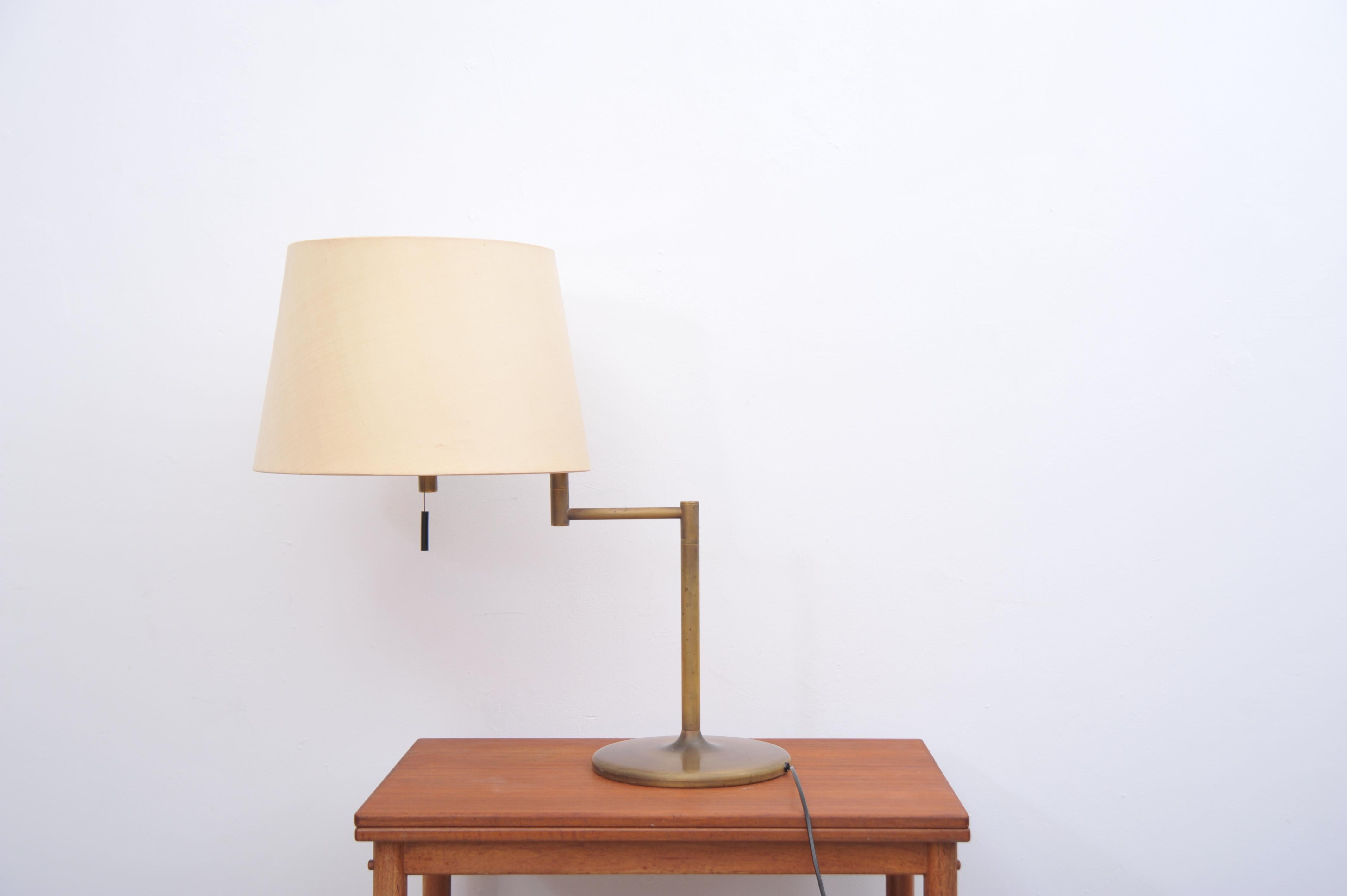 Brass table lamp produced by Swiss Lamps International in the 1970s. The lamp features a rotating arm and a wide, flared shade, combining functionality with timeless design. Good vintage condition with signs of age.