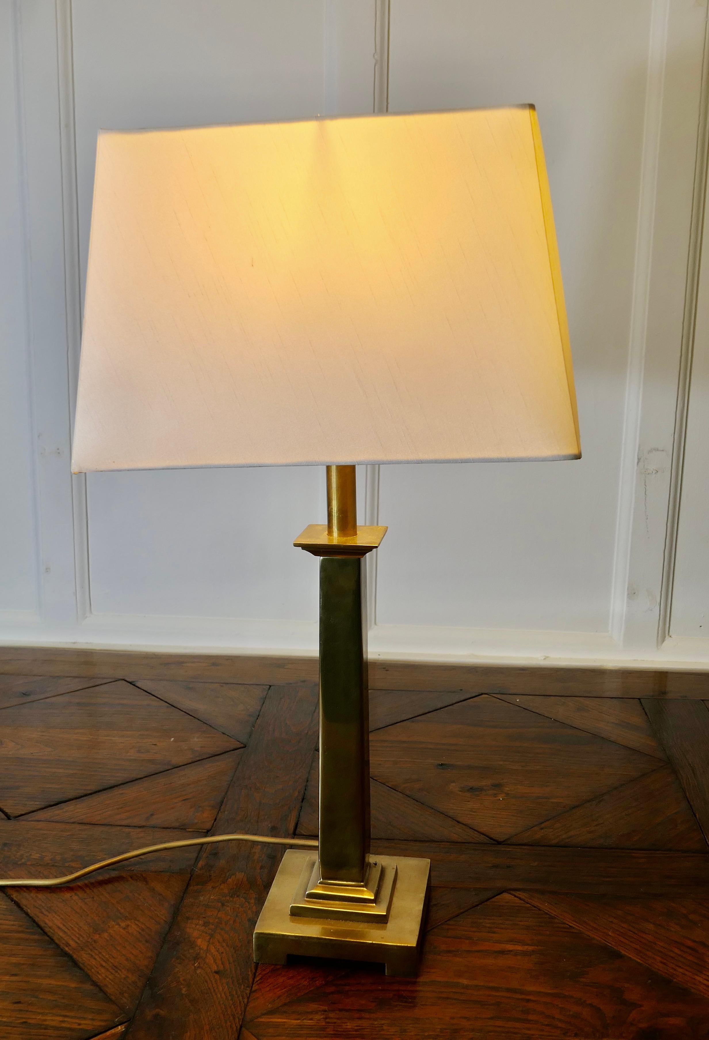 Lampe de table en laiton avec colonne centrale
 
Cette lampe est fabriquée en laiton et possède une colonne carrée avec une base en gradins.
La lampe a son abat-jour rectangulaire en lin d'origine et mesure 24