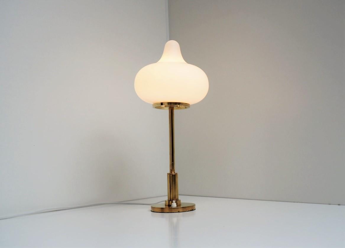Table lamp made in brass with a beautiful shaped opal glass shade. The lamp is designed by Mogens Hammer and Henning Moldenhawer for Louis Poulsen in 1950s.

It gives a gentle illumination almost like as a lighting sculpture with this adorable