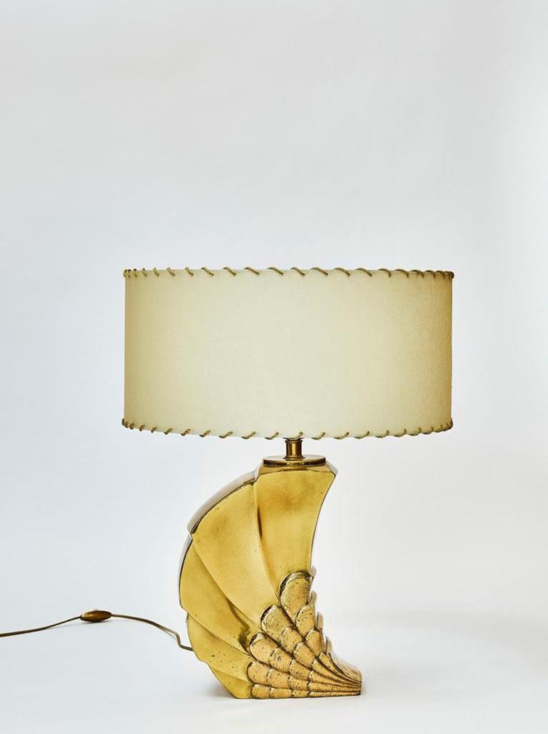 Brass table lamp shaped like a snail with a parchment paper drum shade.