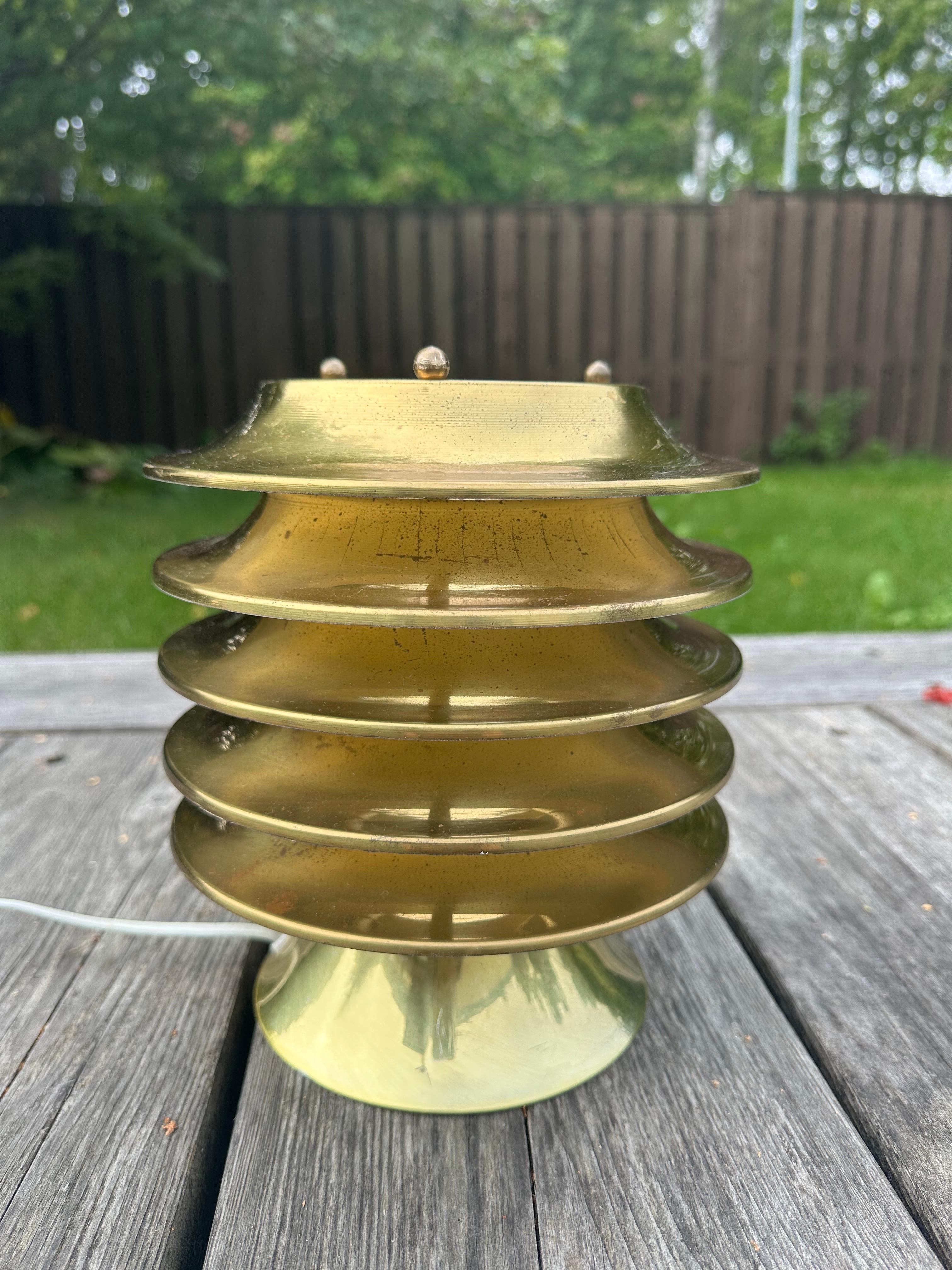 Lampe de table en laiton de Kai Ruokonen Lynx Edition, dans une forme robuste. Fabriqué dans un cylindre de lamelles empilées qui diffusent une lumière chaude et brillante. Une lumière d'ambiance merveilleuse et fraîche.
