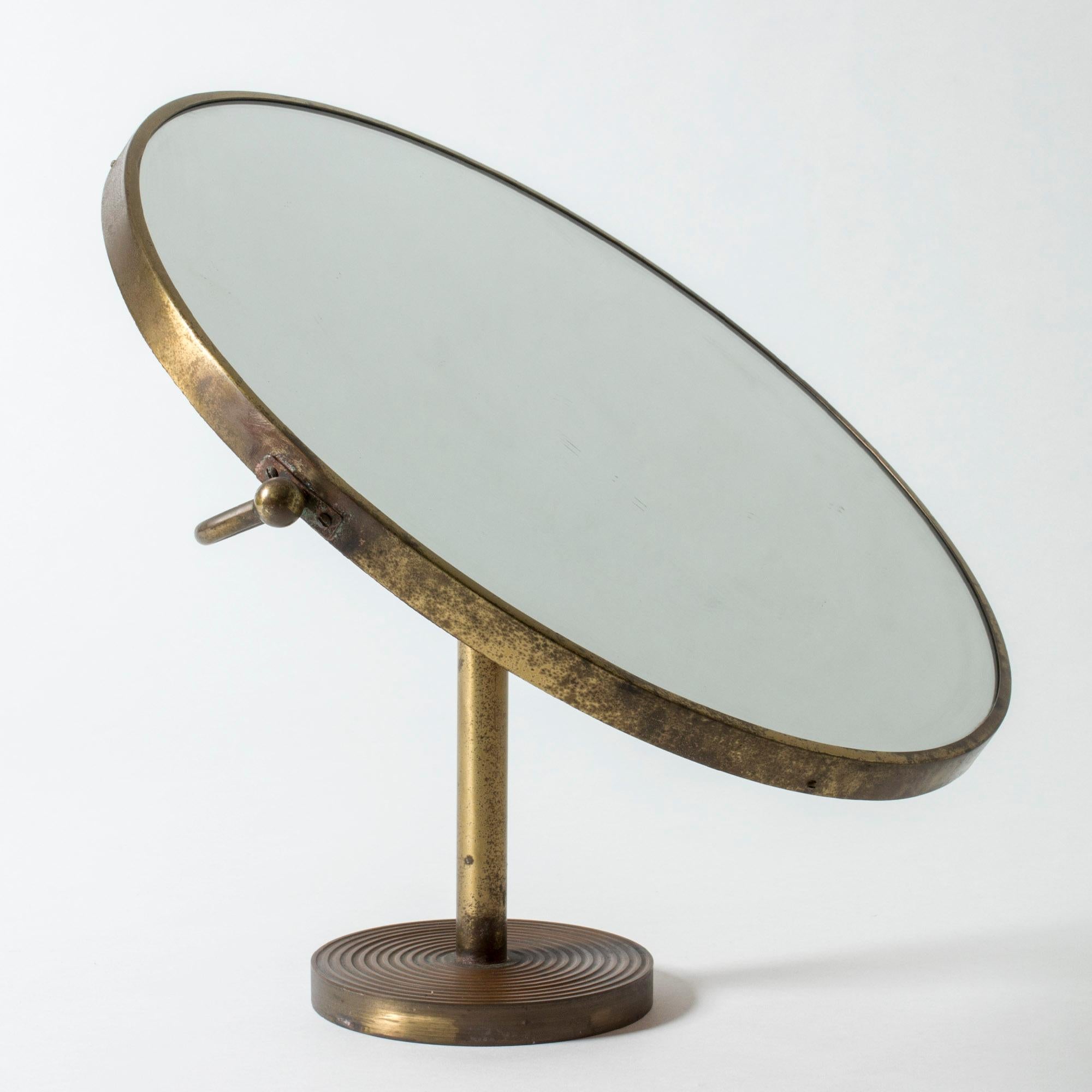 Oversized, round brass table mirror by Josef Frank with heavy brass patina. Clean, elegant lines. Beautiful embossed pattern of stripes on the base of the mirror, wooden back.