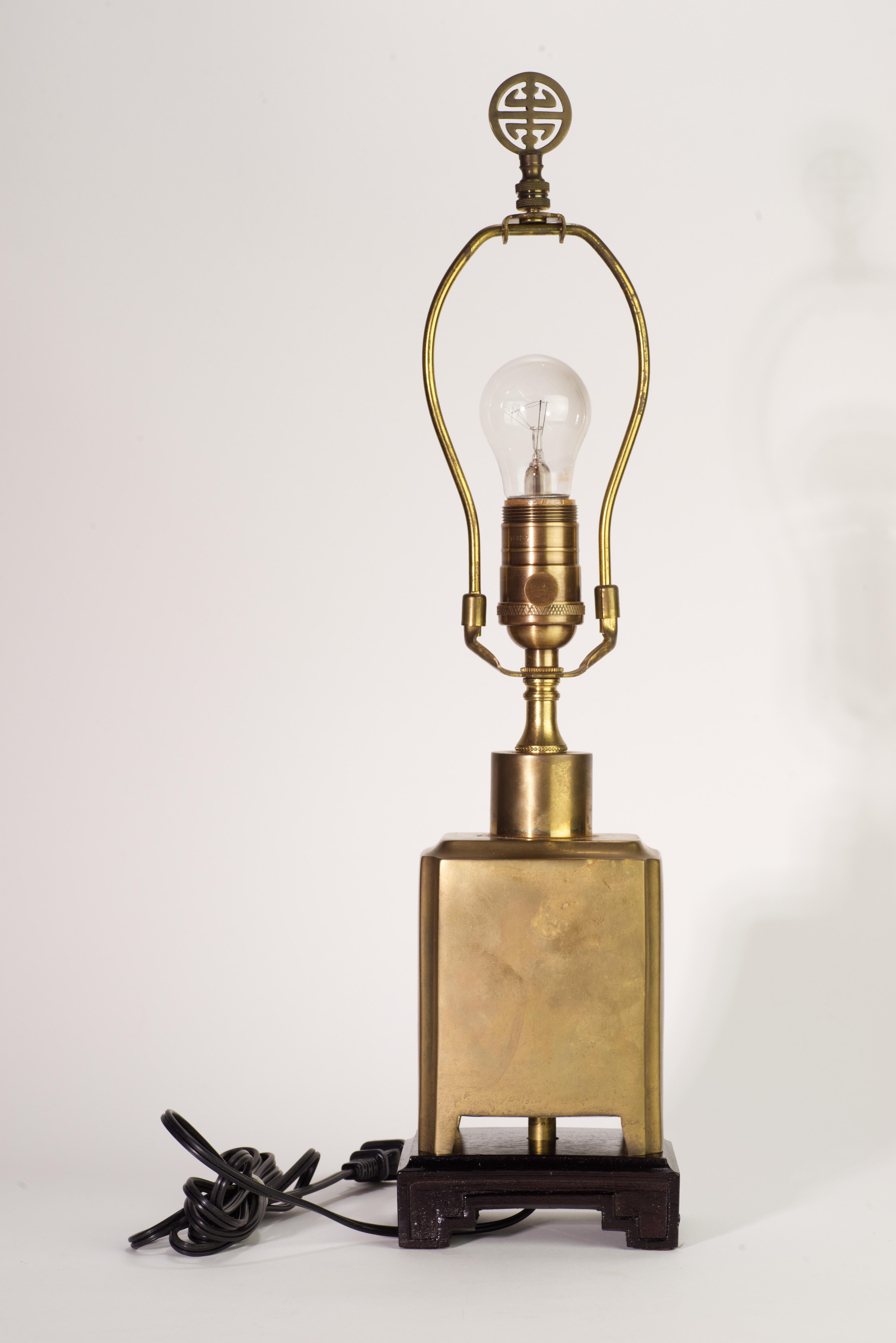  Rare lampe d'appoint ou lampe de table vintage au corps rectangulaire sculptural soutenu par des pieds en forme et monté sur une base en bois. La lampe est livrée avec la harpe d'origine et le fleuron asiatique 
