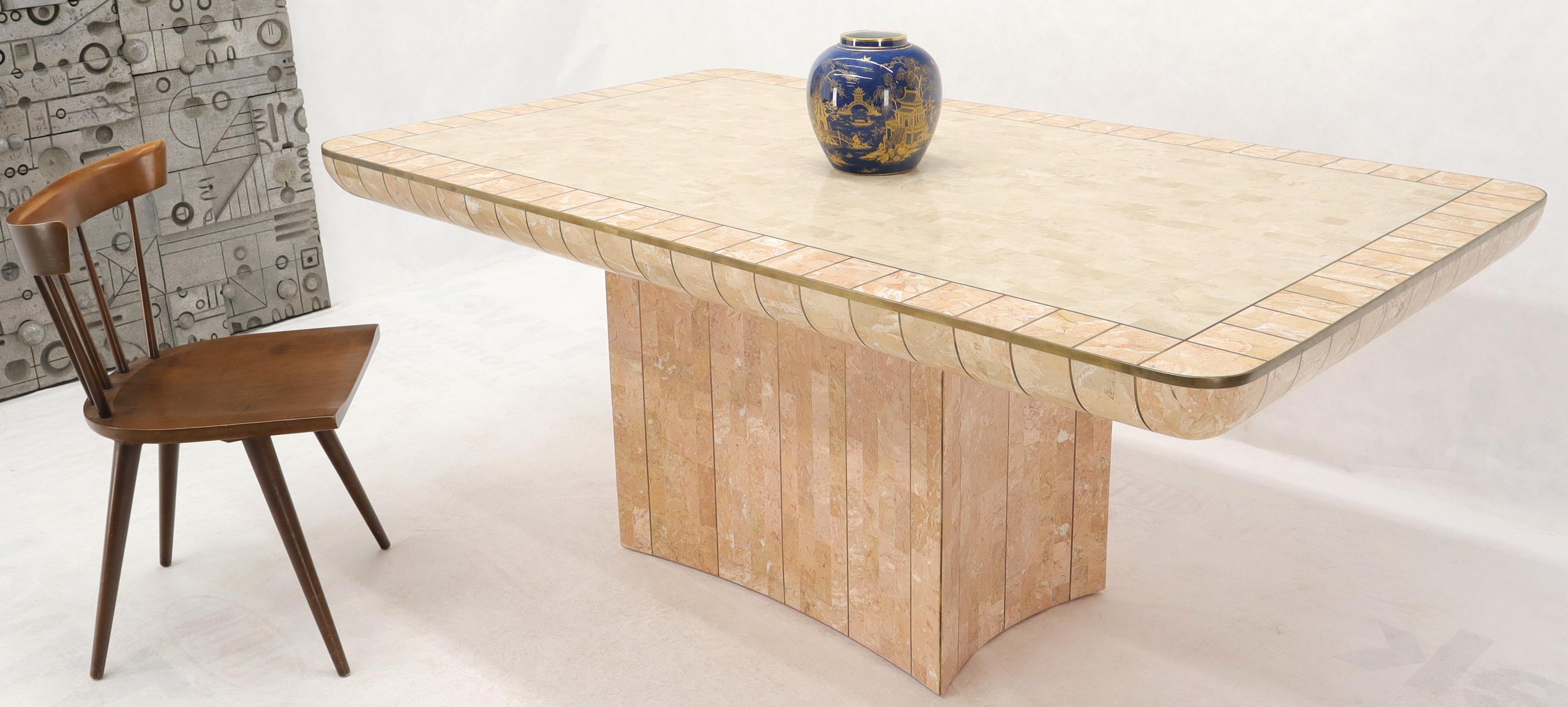 Mid-Century Modern concave pedestal base tessellated stone dining or conference table. Thick curved edge decorated with multiple brass inlay ribs top. Beige and pale rouge stone colors combination. Attributed to Enrique Garcel and Maitland Smith.