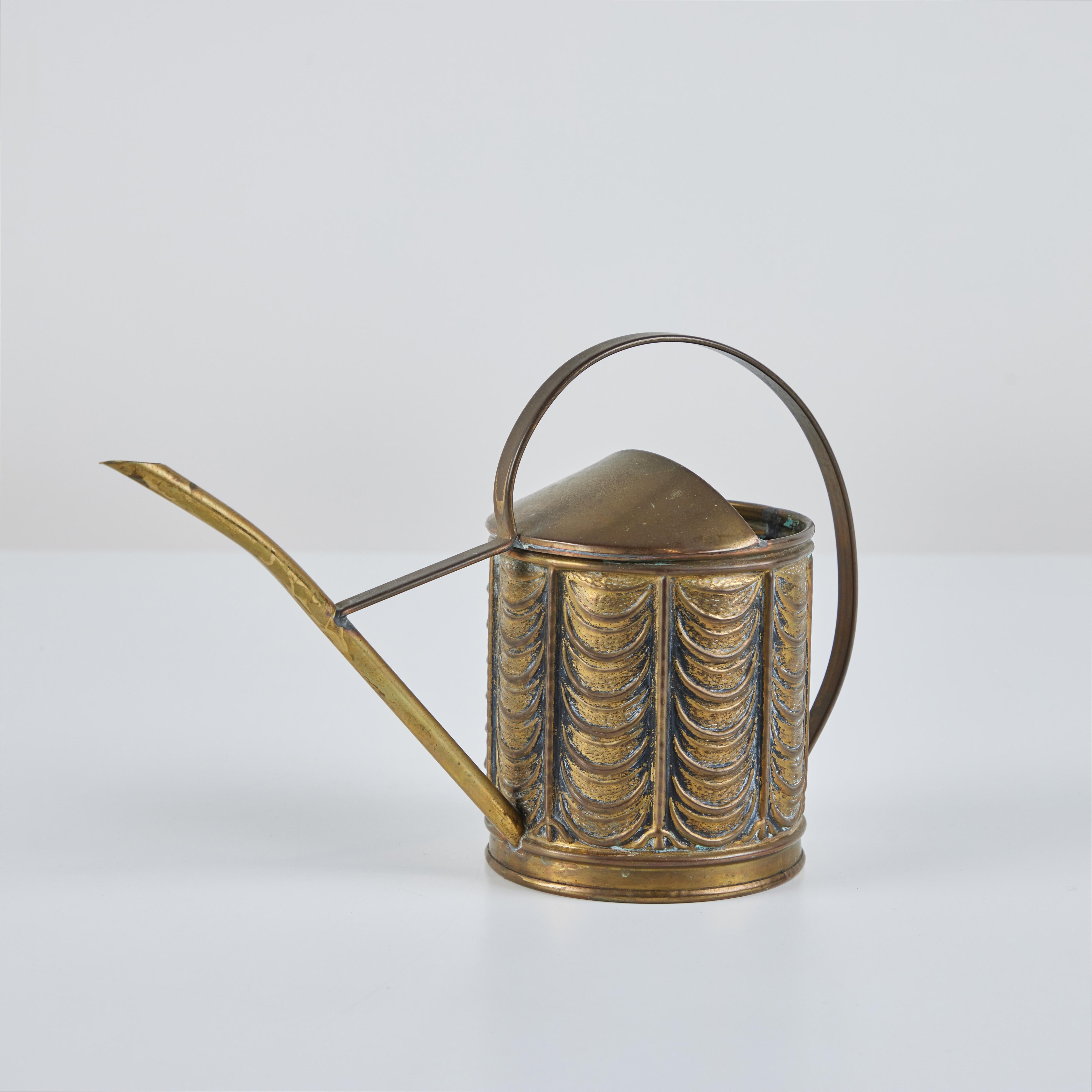 Art Deco brass watering can for Peerage c.1920's, England. This piece features a brass handle and spout with a textured body.
Vessel is impressed Made in England on the underside.

Dimensions
10