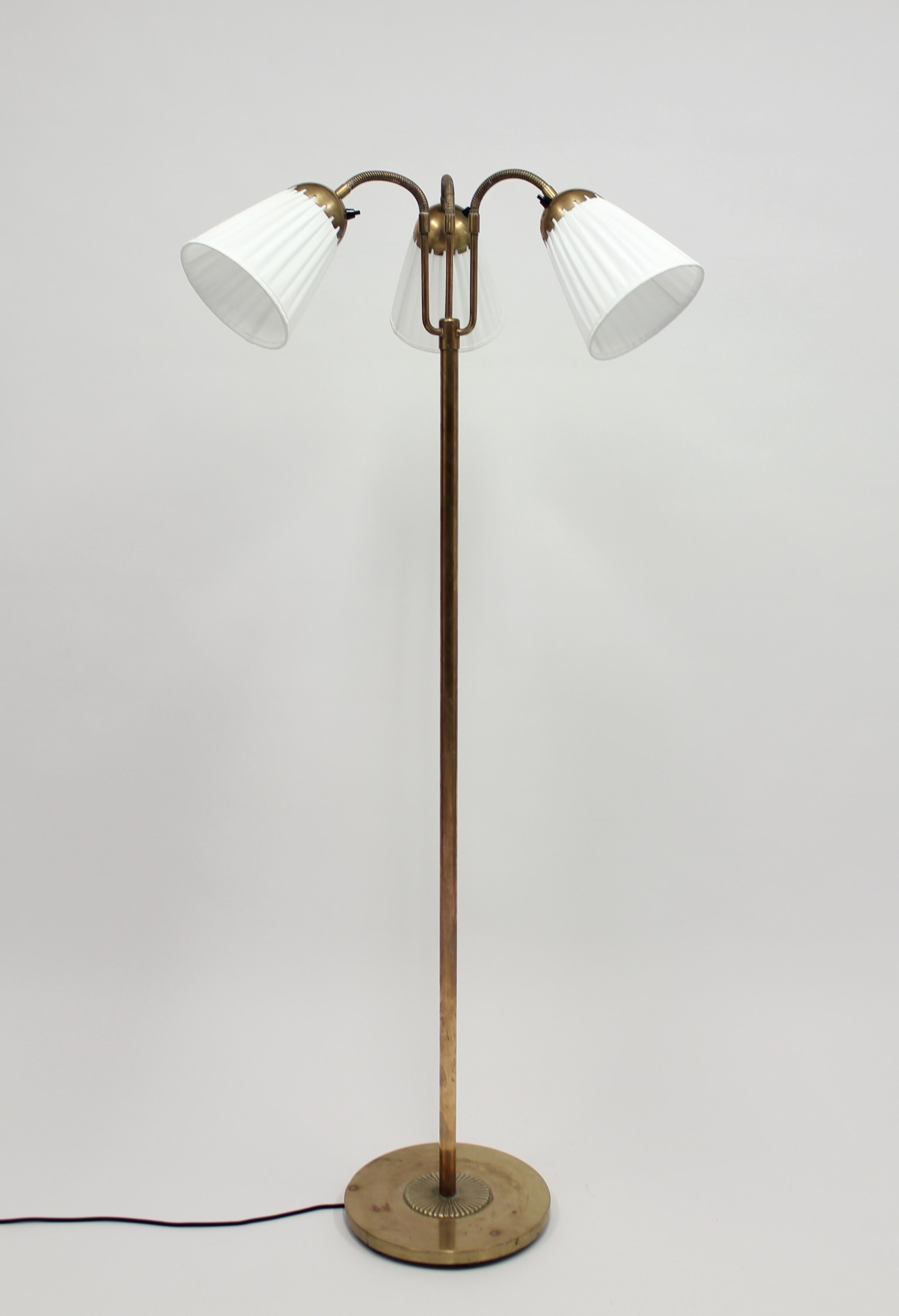 1940s brass three-light floor lamp with pleated shades on so called goose neck arms. Most likely made in Sweden. This is a very good example of the so called 
