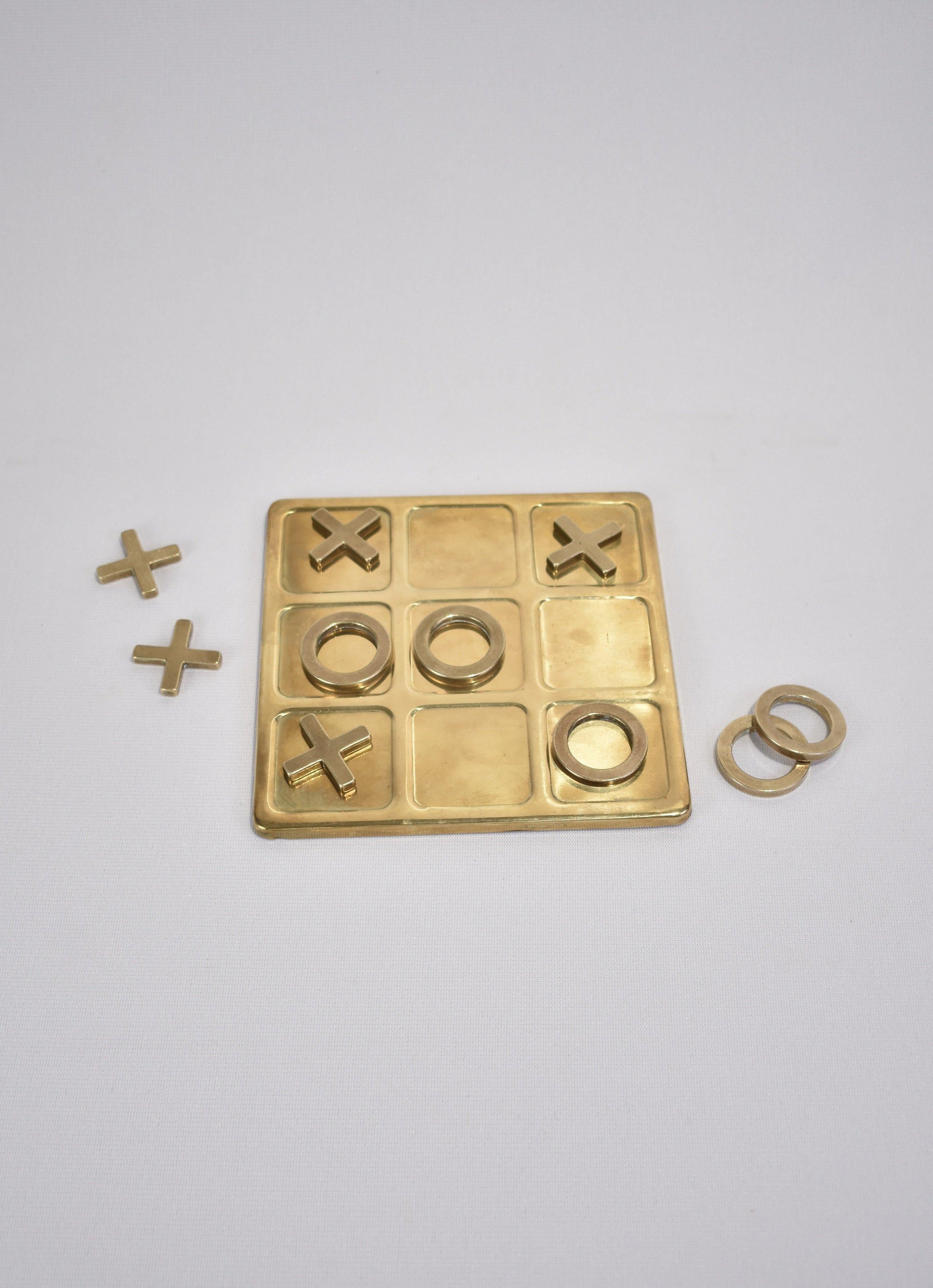 Vintage, brass tic-tac-toe set including board and ten pieces.