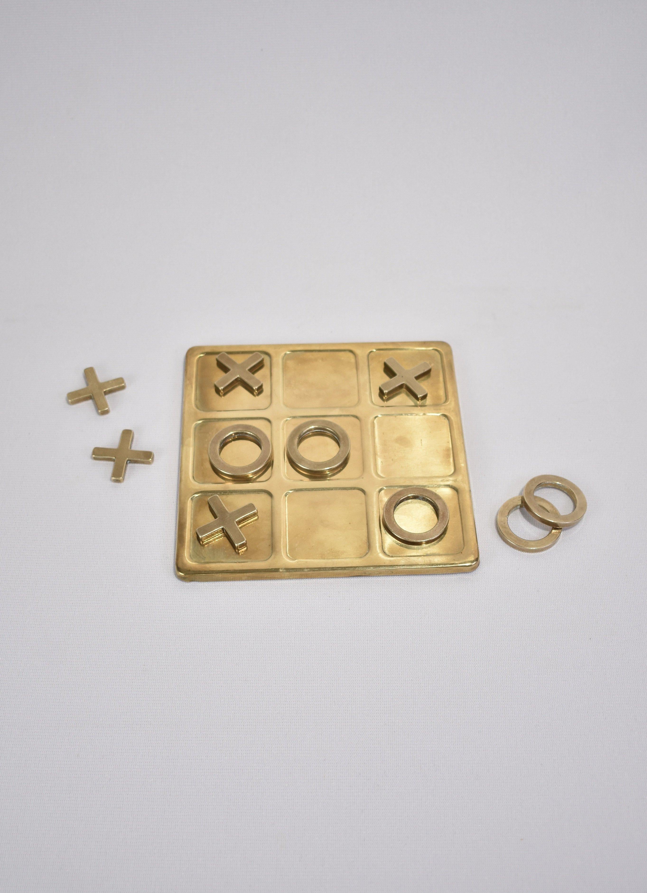 Vintage, brass tic-tac-toe set including board and ten pieces.