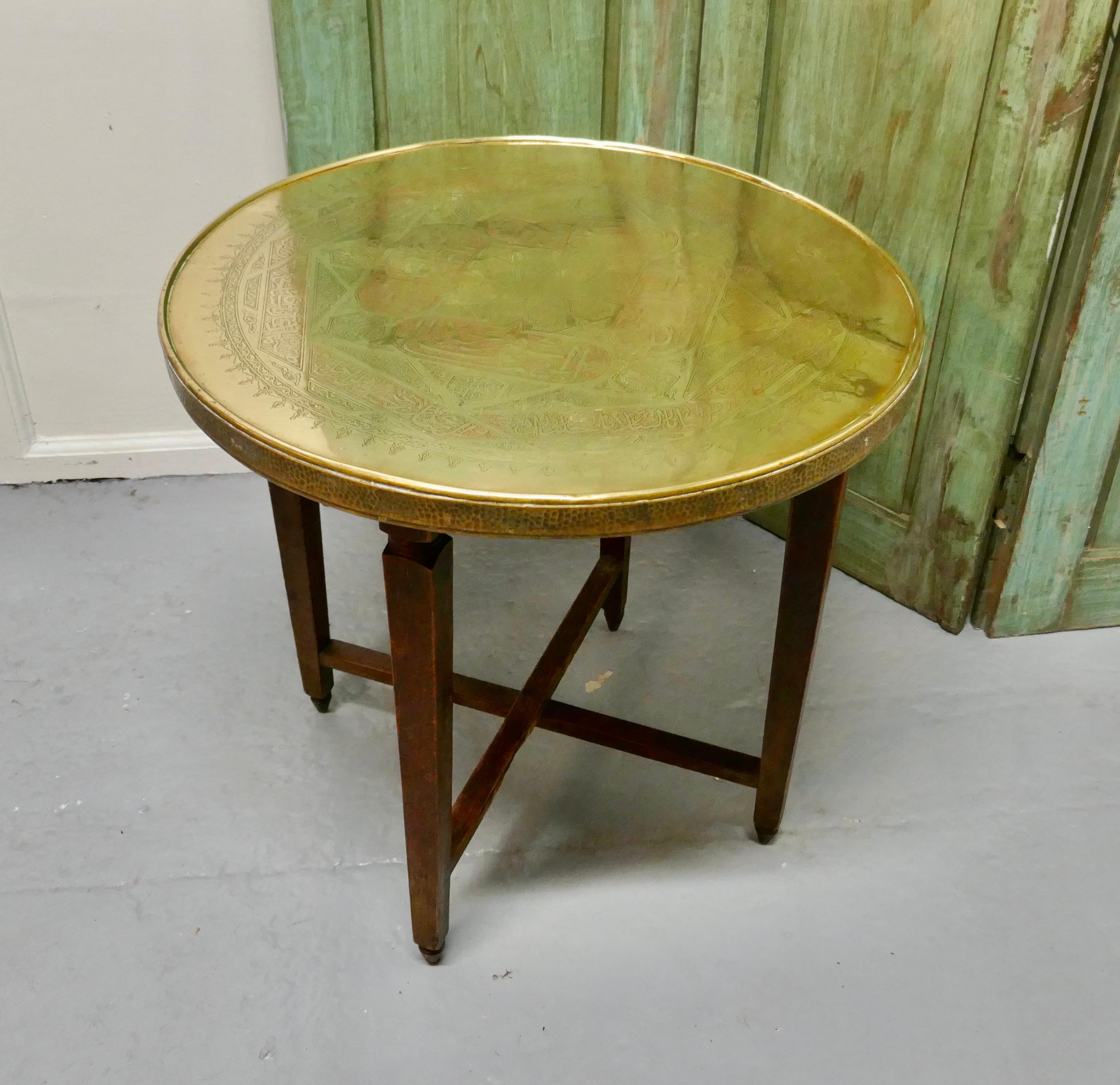 Brass top coffee table or occasional table

The table stands on sturdy oak legs with stretchers and a removable brass tabletop.
The 2” thick round tabletop is beautifully made in eastern style decorative brass and the legs can be folded flat when