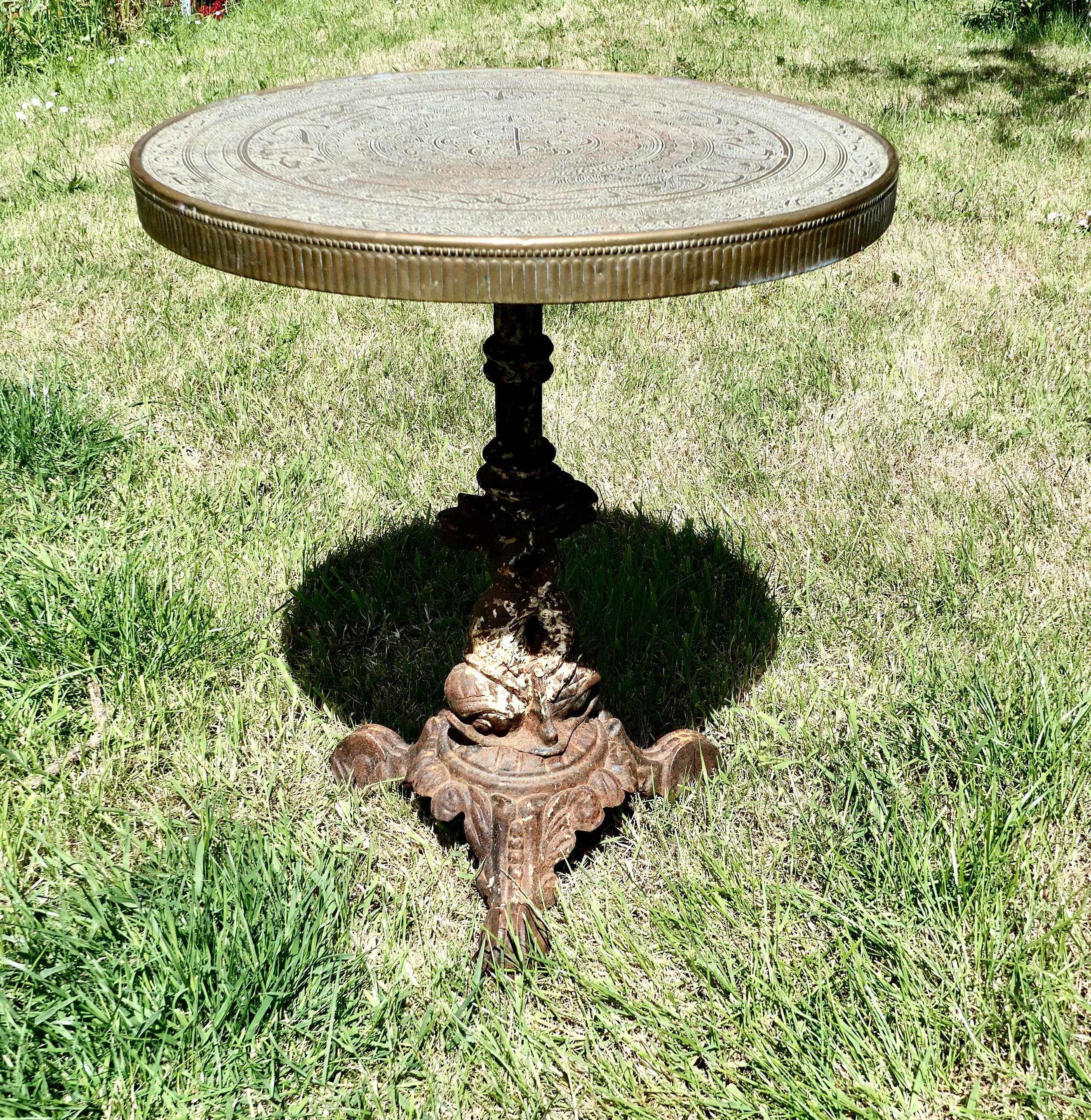Brass Top Garden Iron Table 

The round brass table top sits on a Victorian cast iron leg, the leg takes the form of a Dolphin and the table top is supported on his tail 
The 2” thick round table top is made in eastern style decorative brass, there
