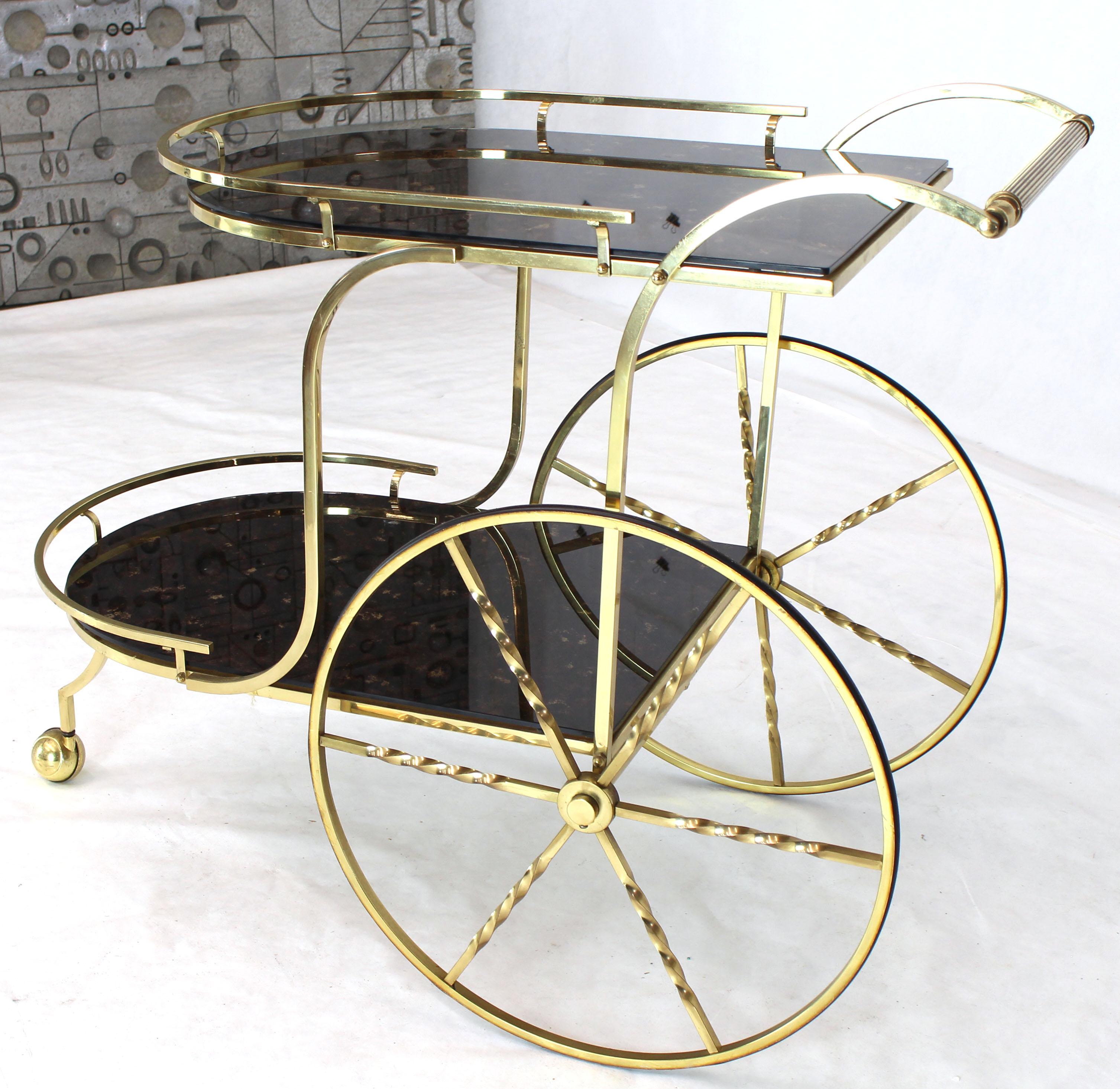 Decorative Mid-Century Modern two-tier bar tea serving cart on large carriage style brass wheels. The lower level is 12