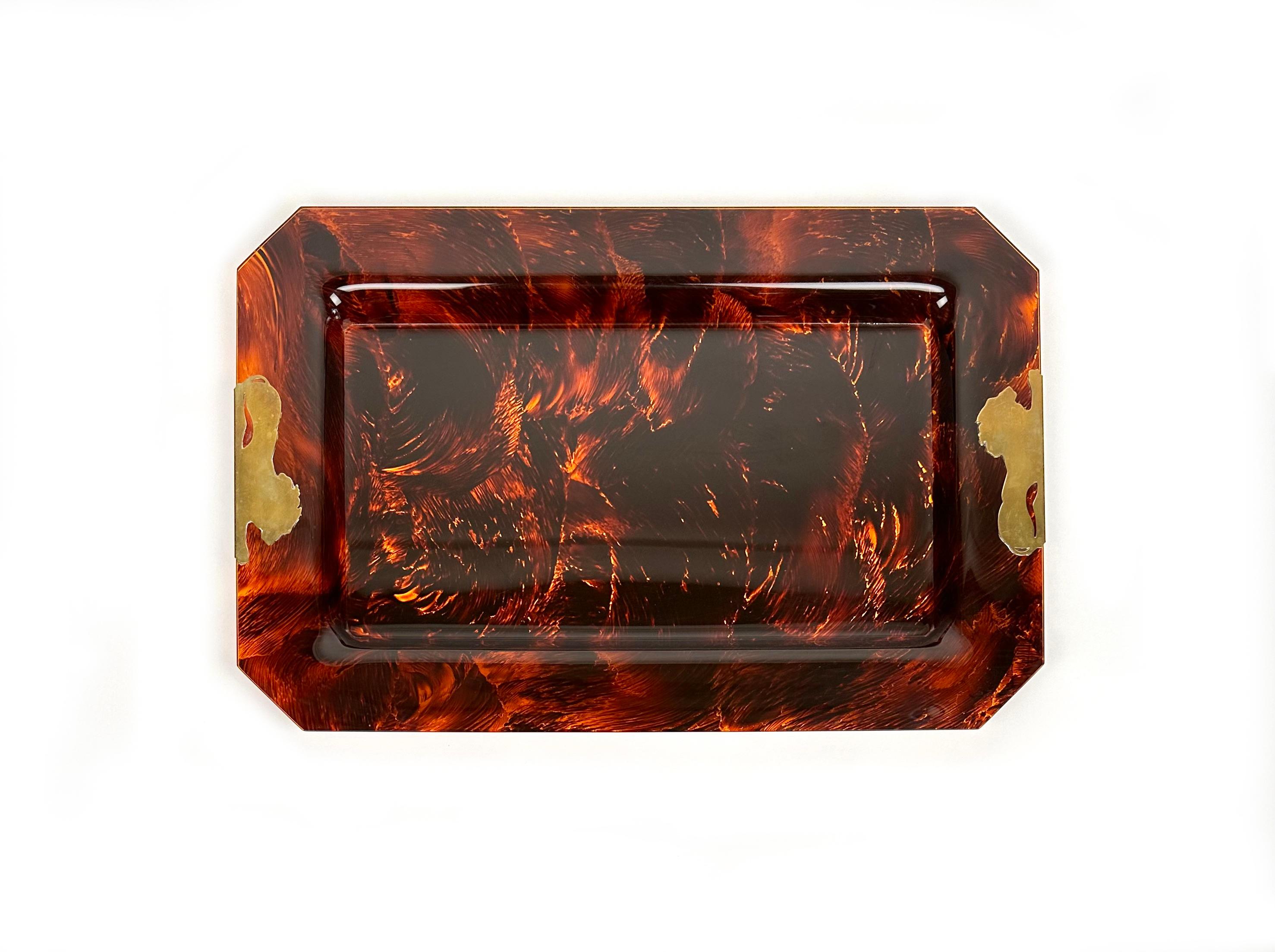 Rectangular centerpiece serving tray in tortoise-shell-effect lucite featuring two brass lions on two sides.

Made in Italy in the 1970s.