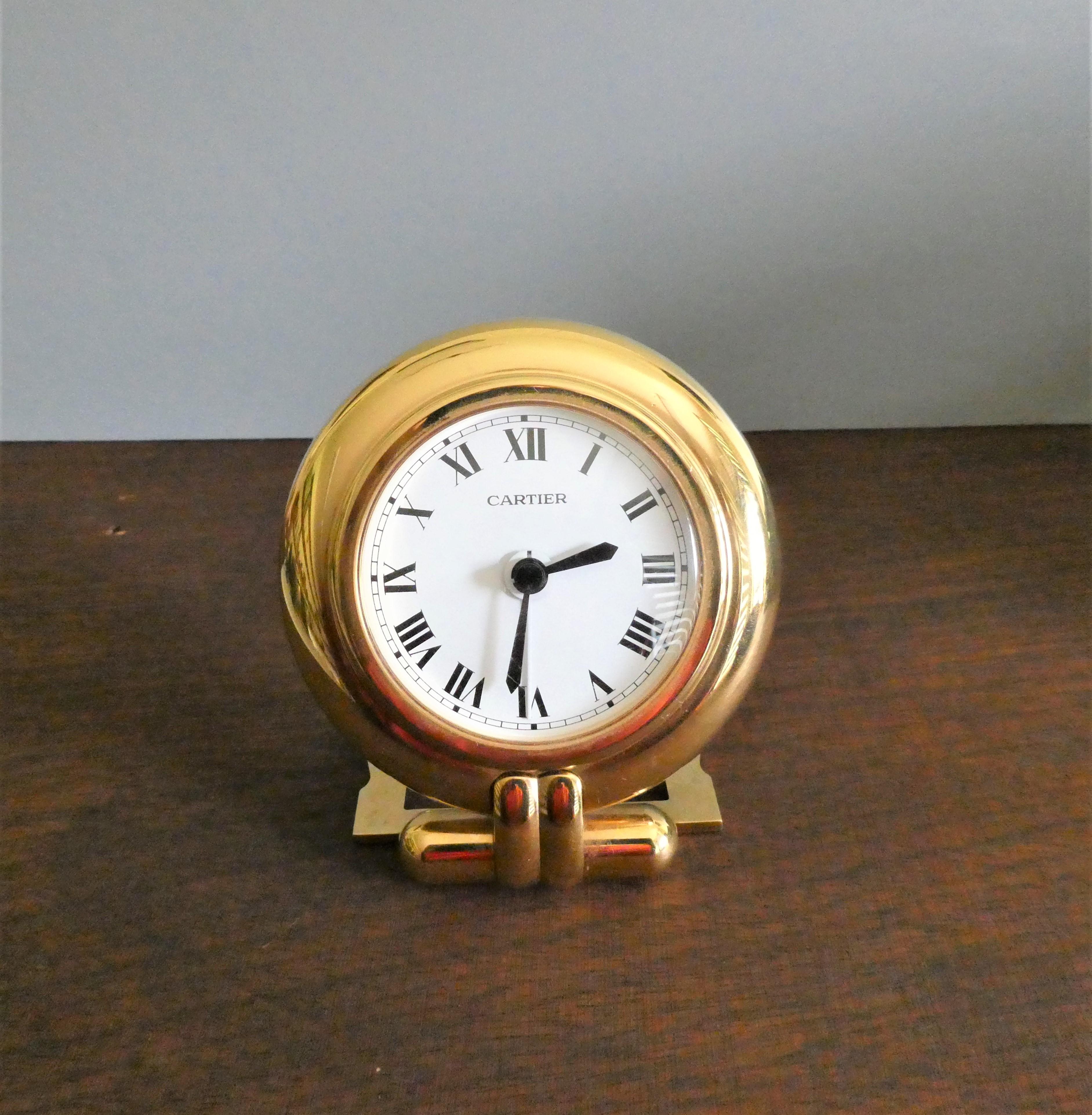 Travel Alarm Clock by Cartier

The clock housed in a round brass frame with decorative hinged strut support.

Painted dial with Roman numerals, original hands and alarm hand signed ‘Cartier’.

Anodised strut frame supported by two iconic ‘C’