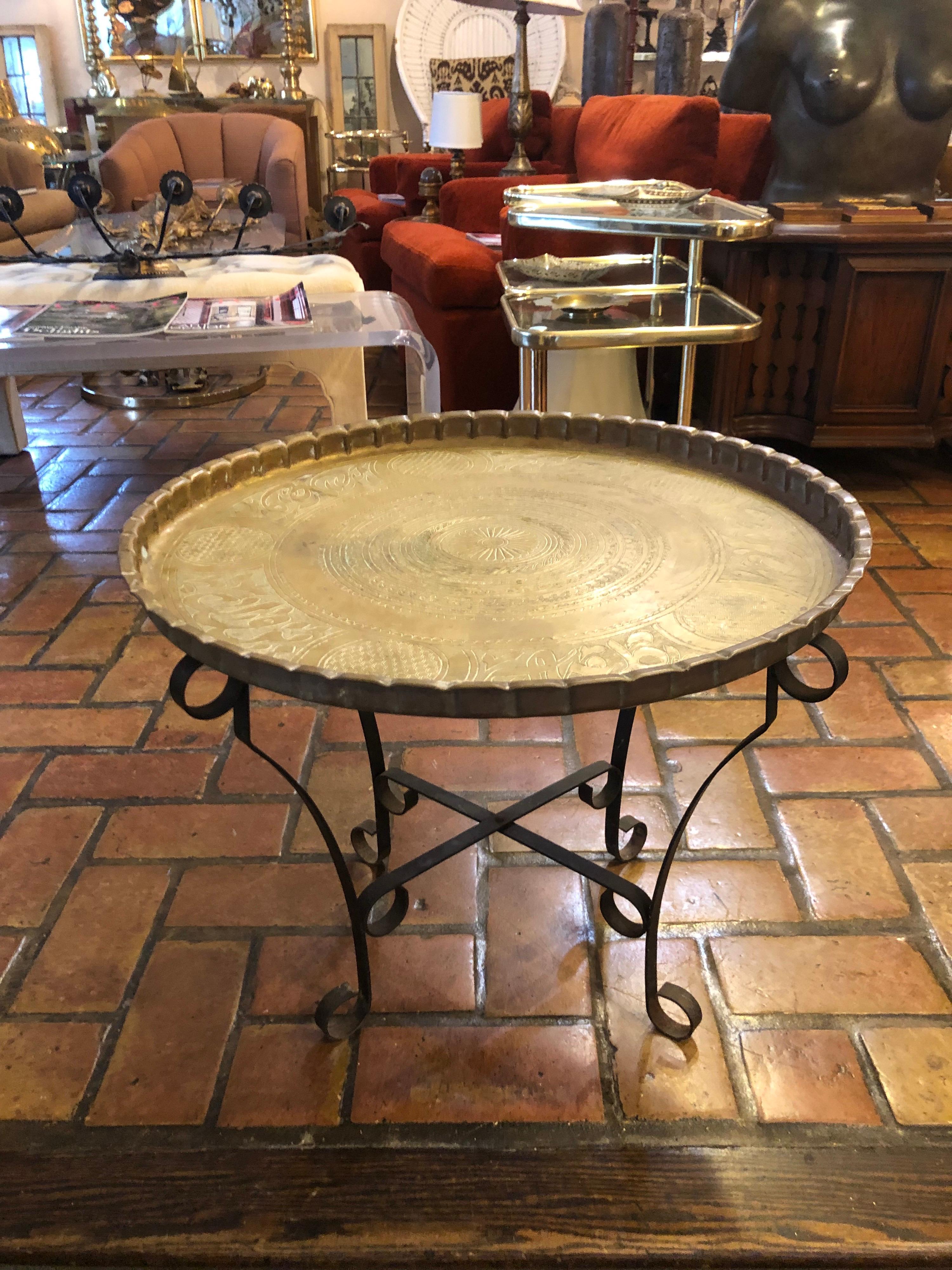 Brass tray table with folding stand. Round chased Brass Tray with fluted edges. Sits on top of a folding iron stand. Please ignore the white glove quote. This item can parcel ship for under $100 via parcel in the continental US.