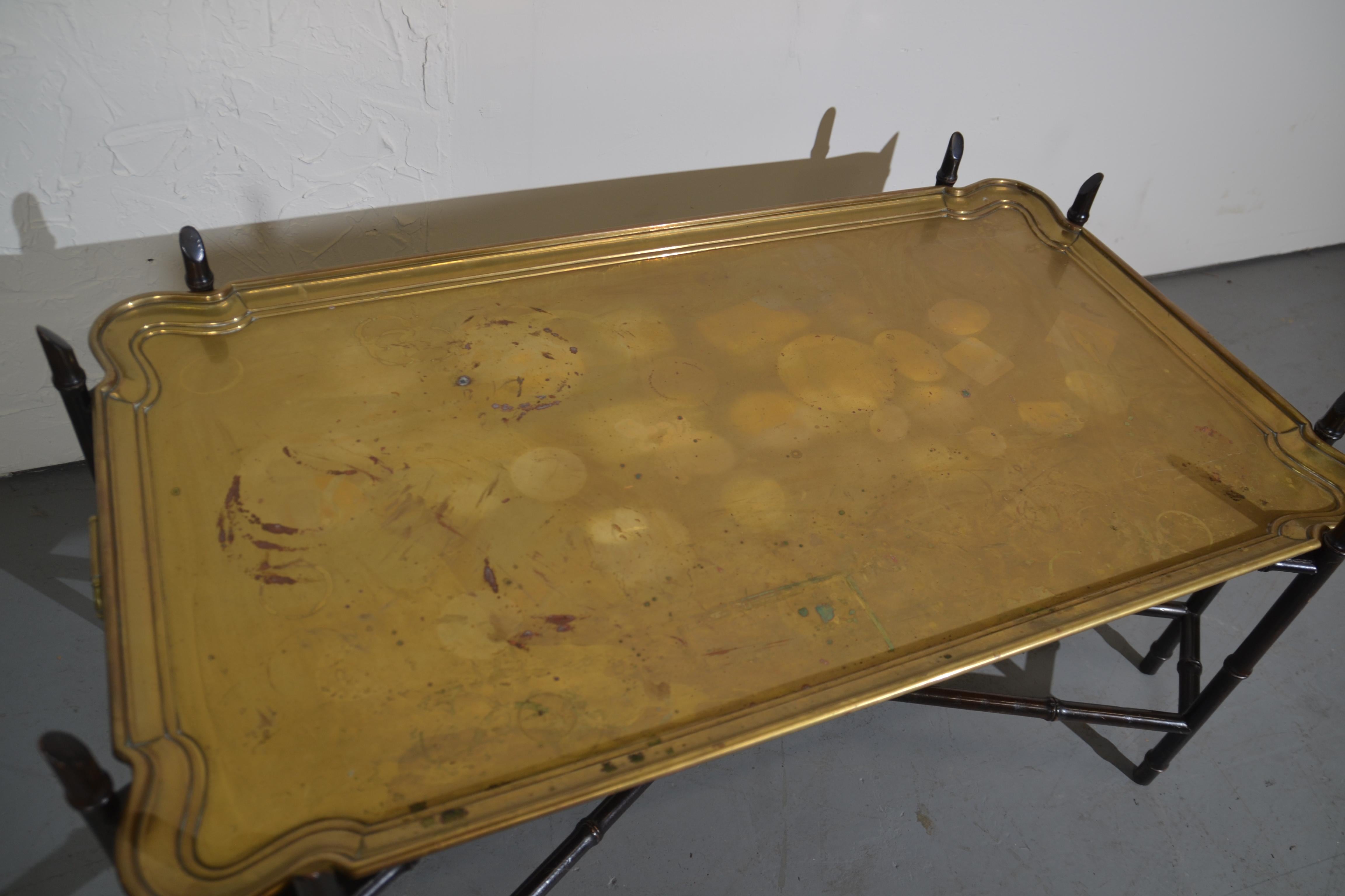 Brass tray top coffee table sitting on a faux-bamboo base. Brass handles on each side.