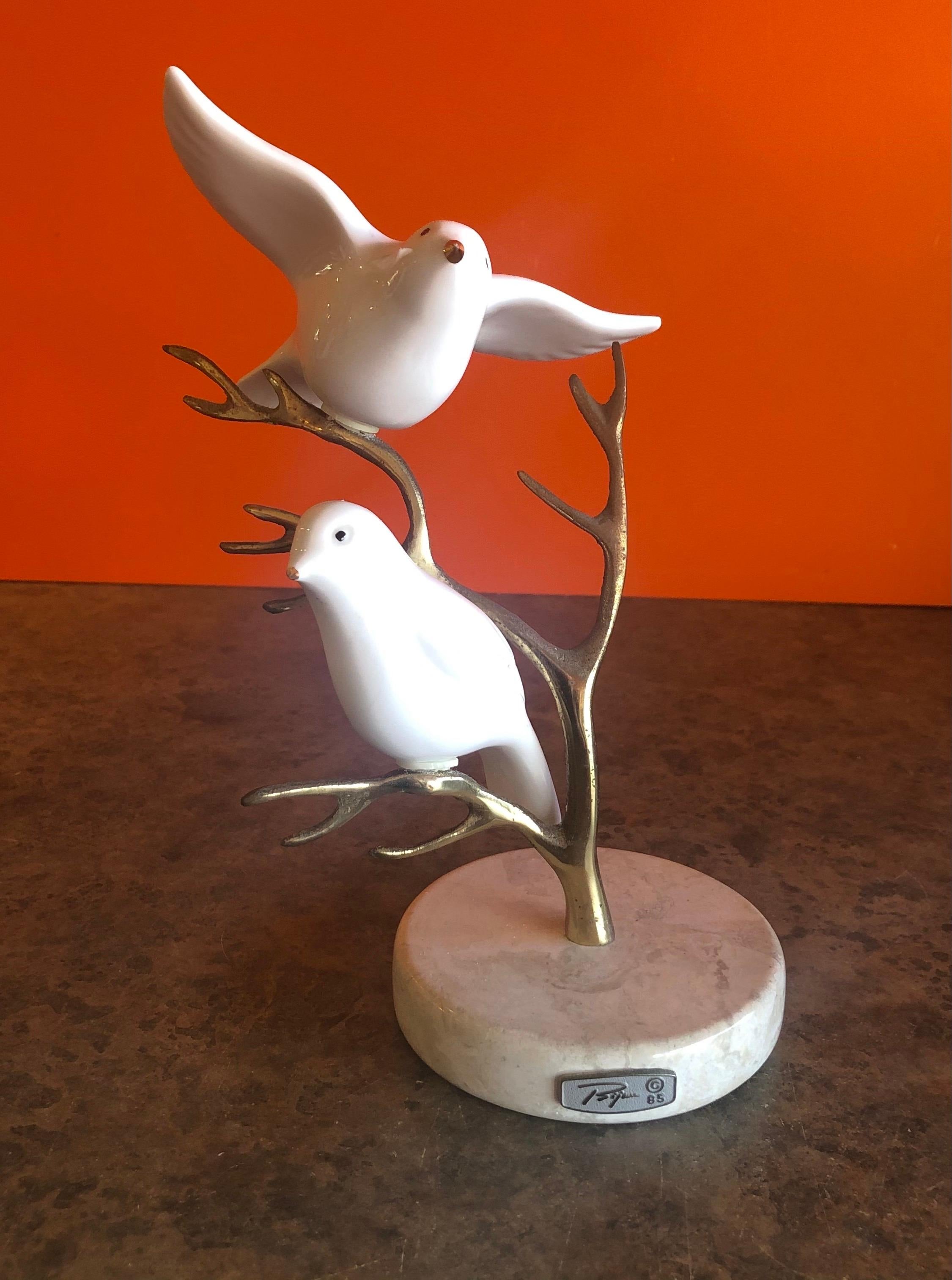 Beautiful brass tree with two white ceramic birds table sculpture by Bijan, circa 1985. The patinated tree sits on a 4