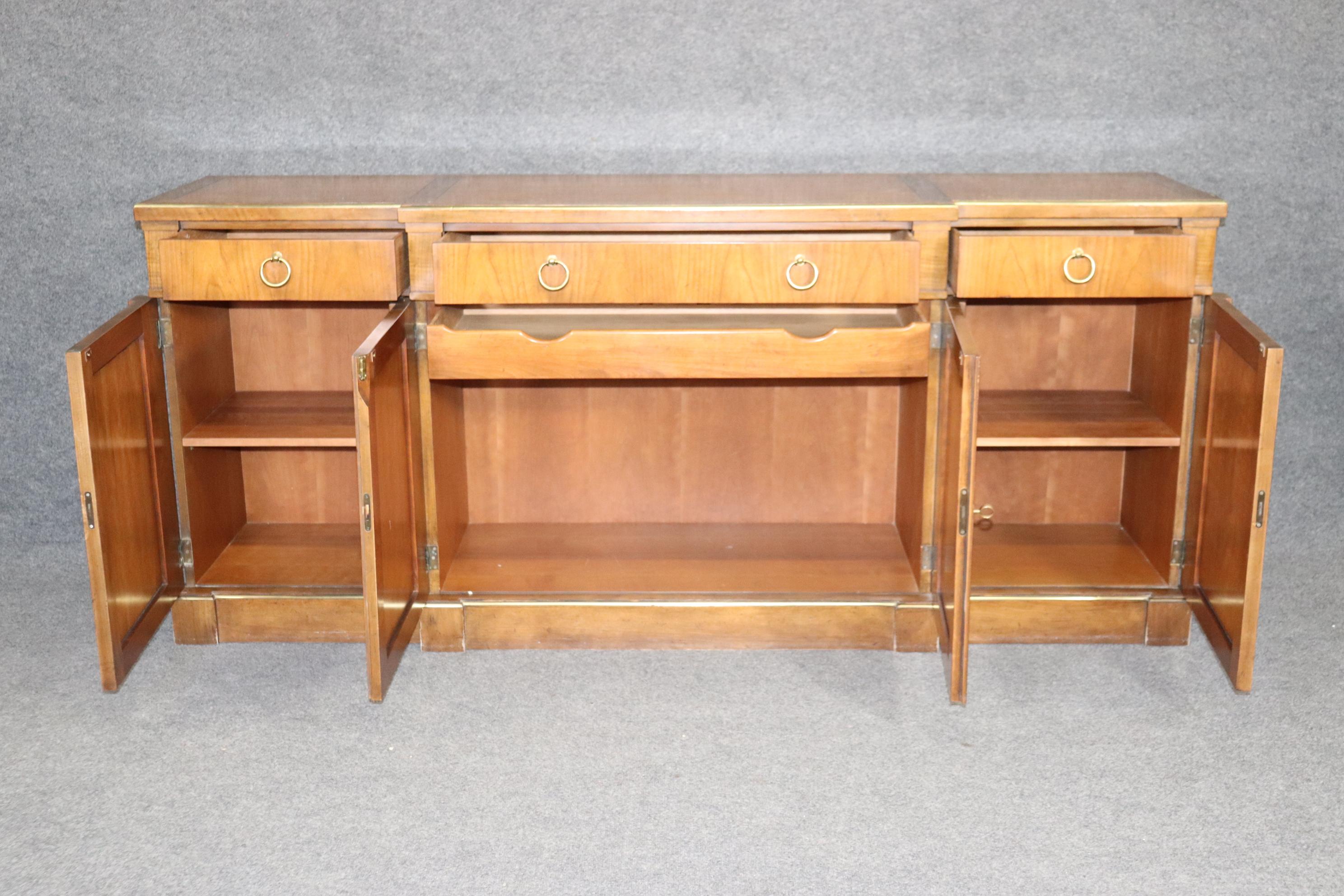 This is a stunning and sublime Baker sideboard in the Directoire manner. The sideboard is in good condition and features bright brass ring pulls and gorgeous brass trimmed doors. The 