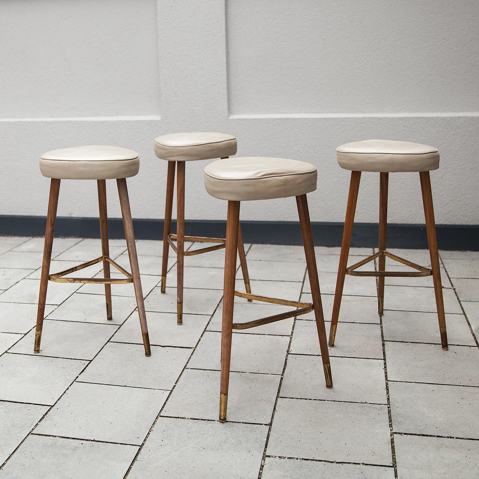 Elegant rare tripod bar stools designed in a tripod oak base with a brass stand and the top is made in light grey leather.