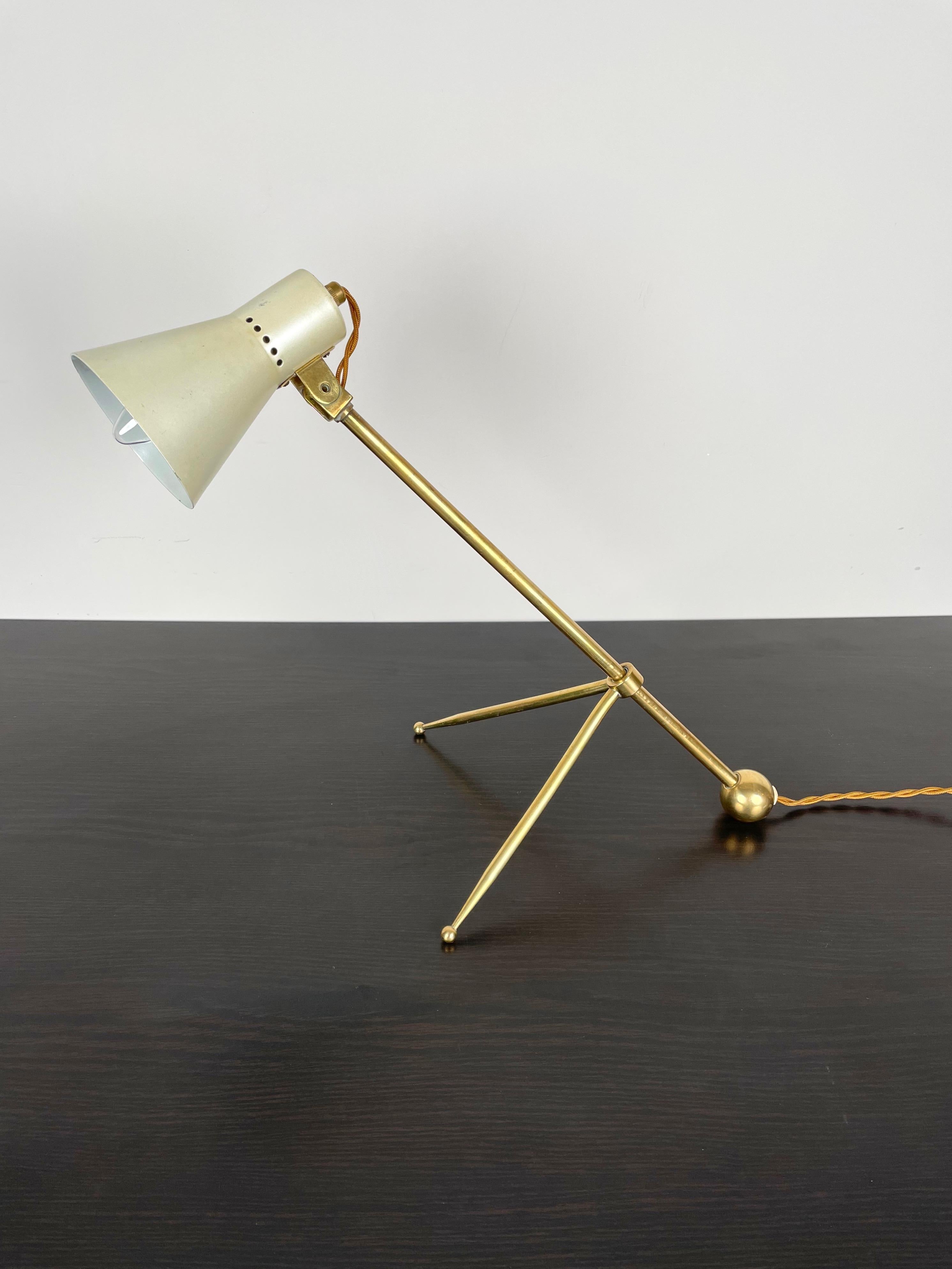 Desk or table lamp in brass tripod structure and adjustable height attributed to Stilnovo. Made in Italy in the 1950s. 
The electrical system was remade new.